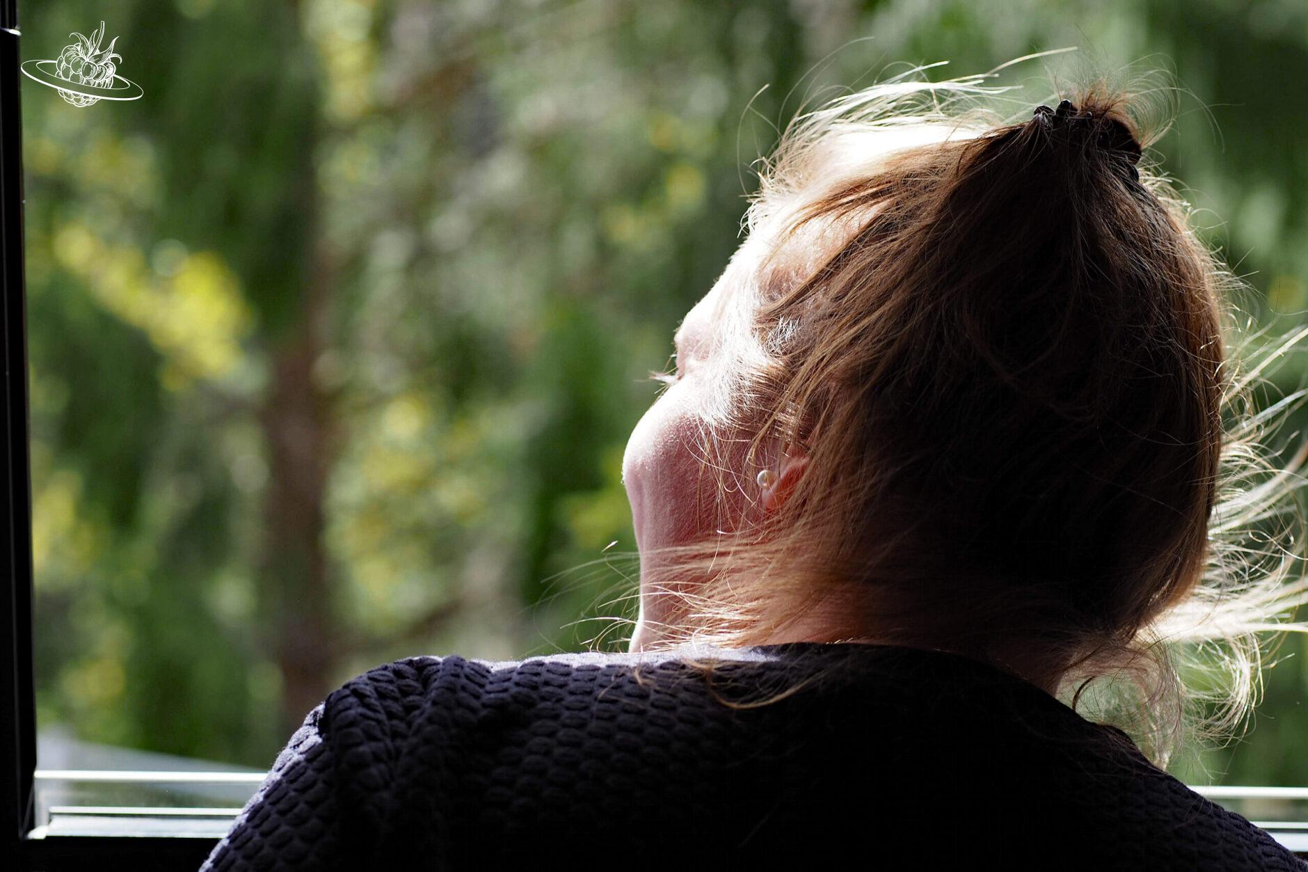 Frau schaut aus dem Fenster