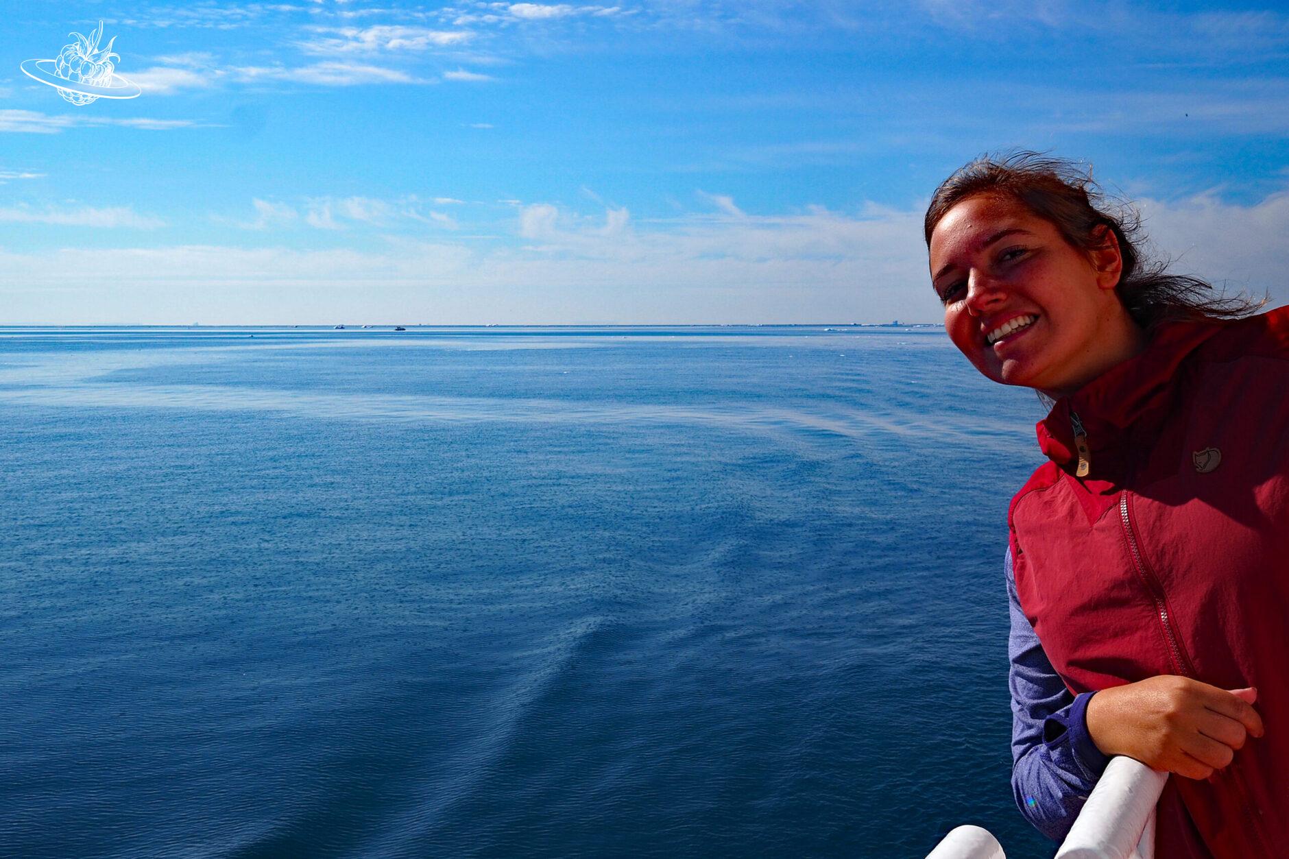 Frau auf Fähre mit Meer im Hintergrund