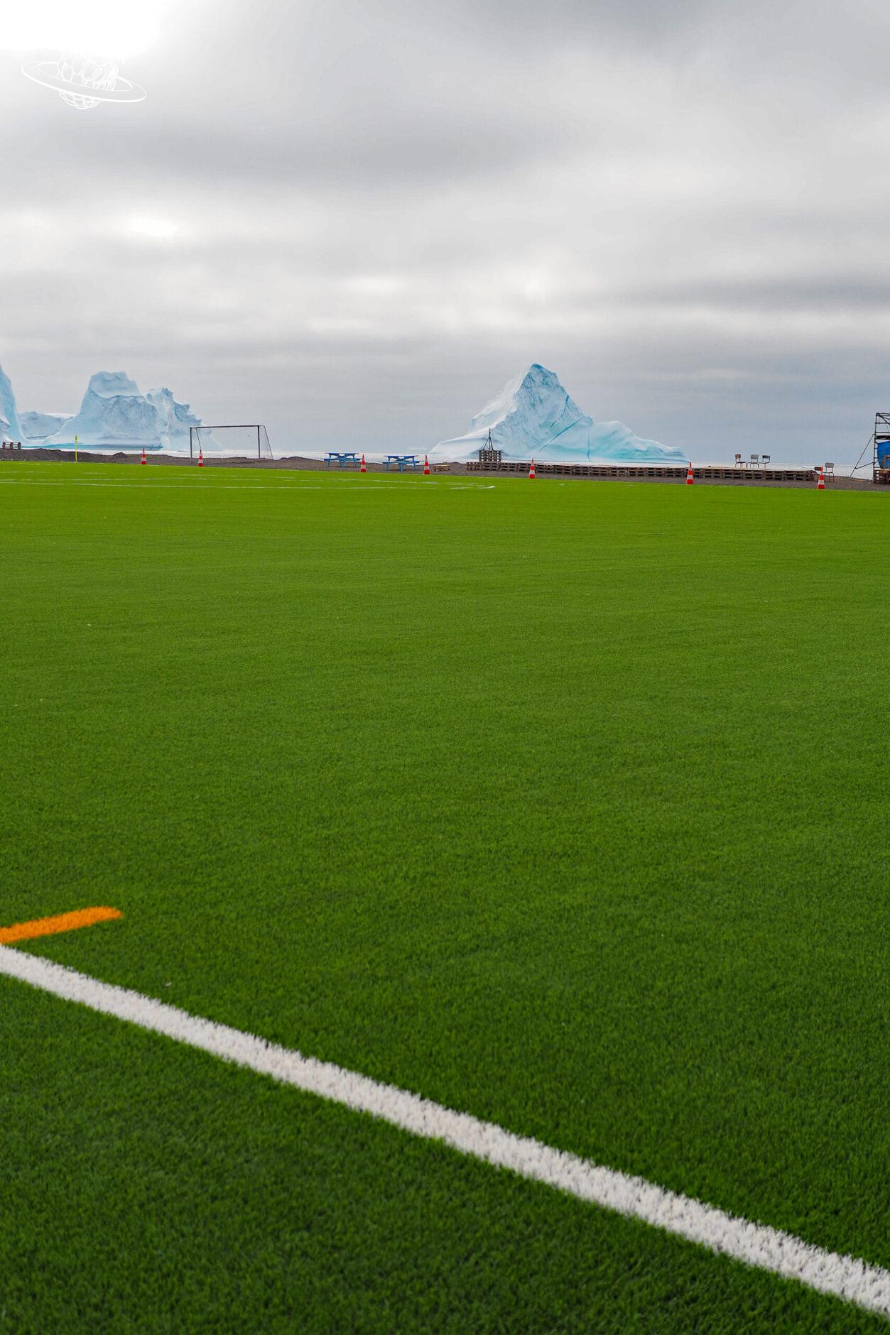 Fussballplatz und im Hintergrund Eisberge der wie das Matterhorn aussieht