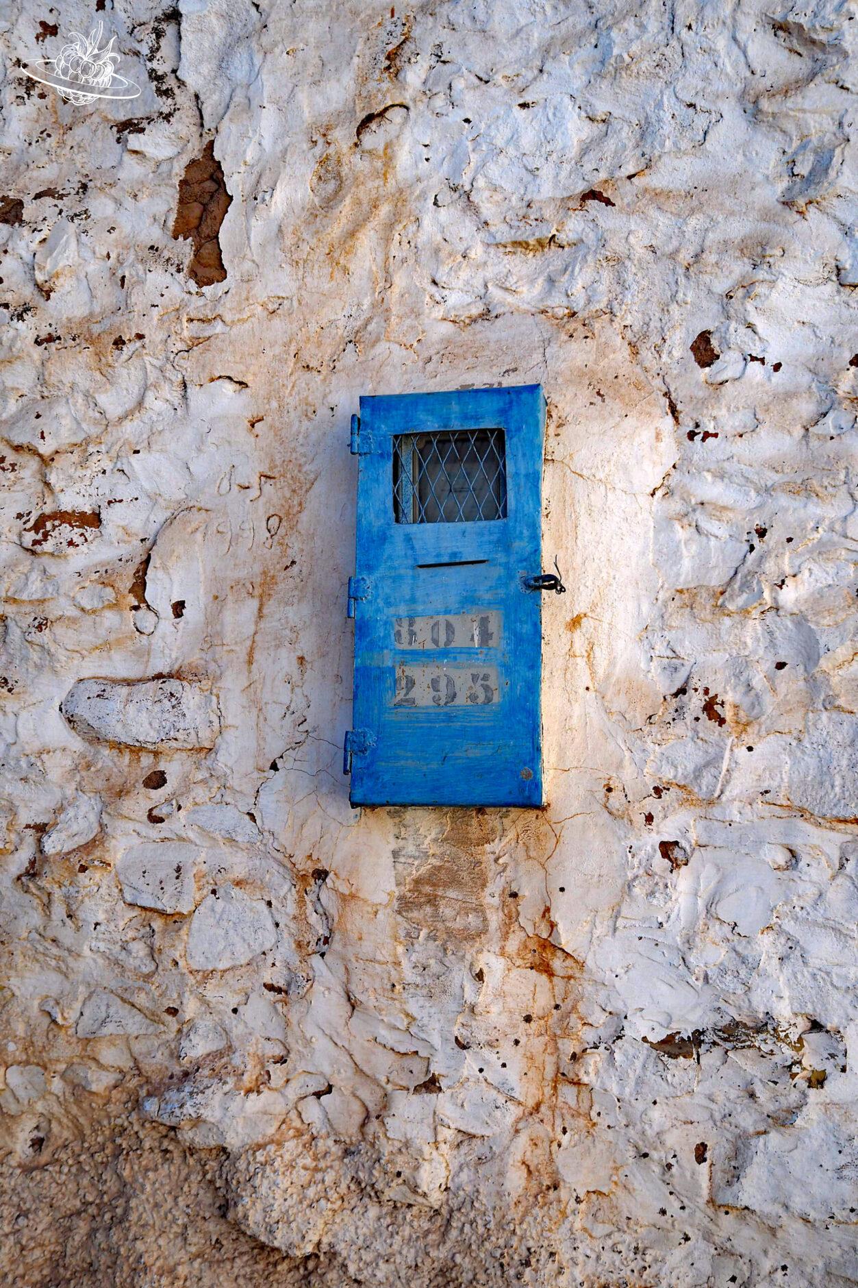 Blauer Kasten in einer weissen Wand