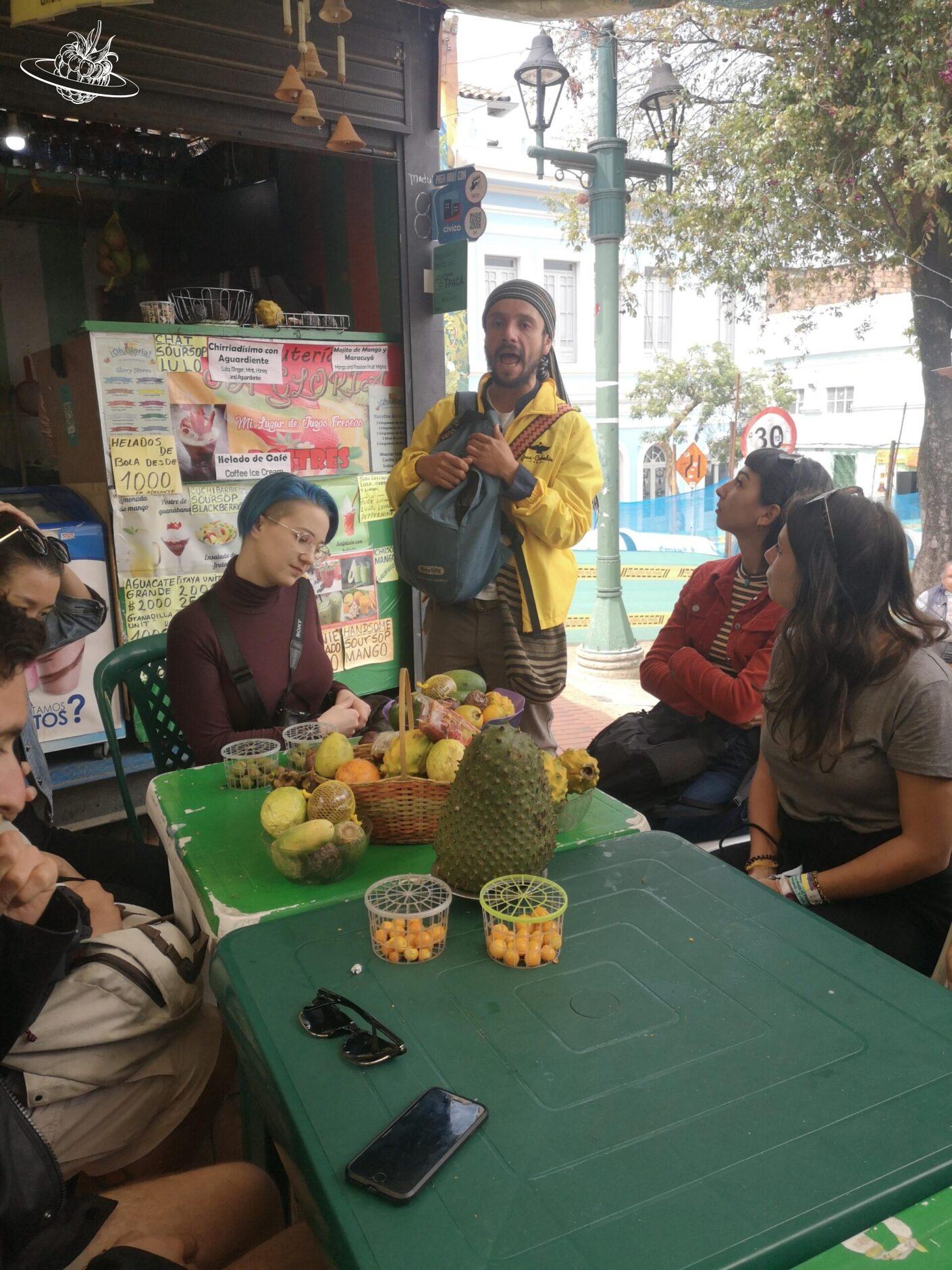 Teilnehmer der Stadtführung sitzen um einen Tisch mit Früchten