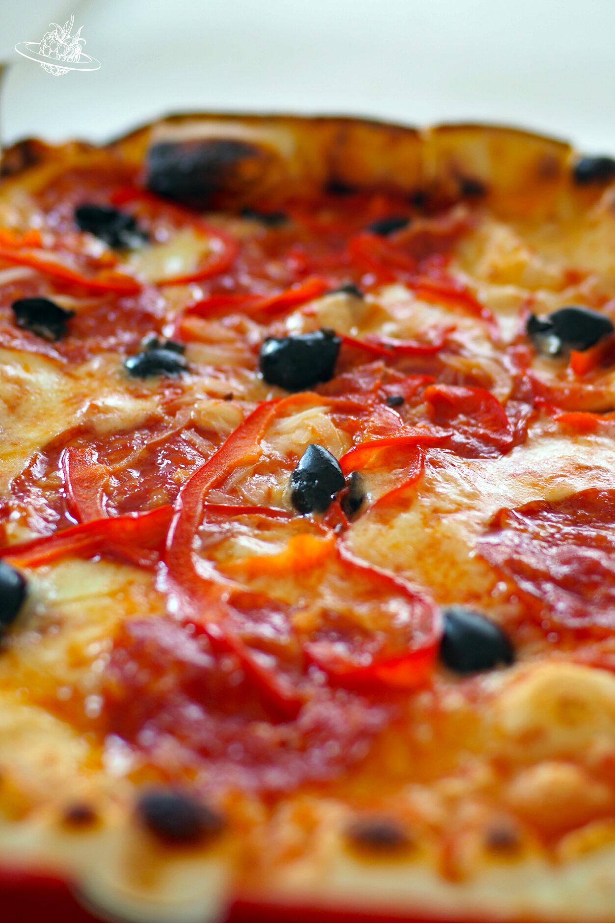 Pizza bestückt mit Peperoni und Salami und Oliven