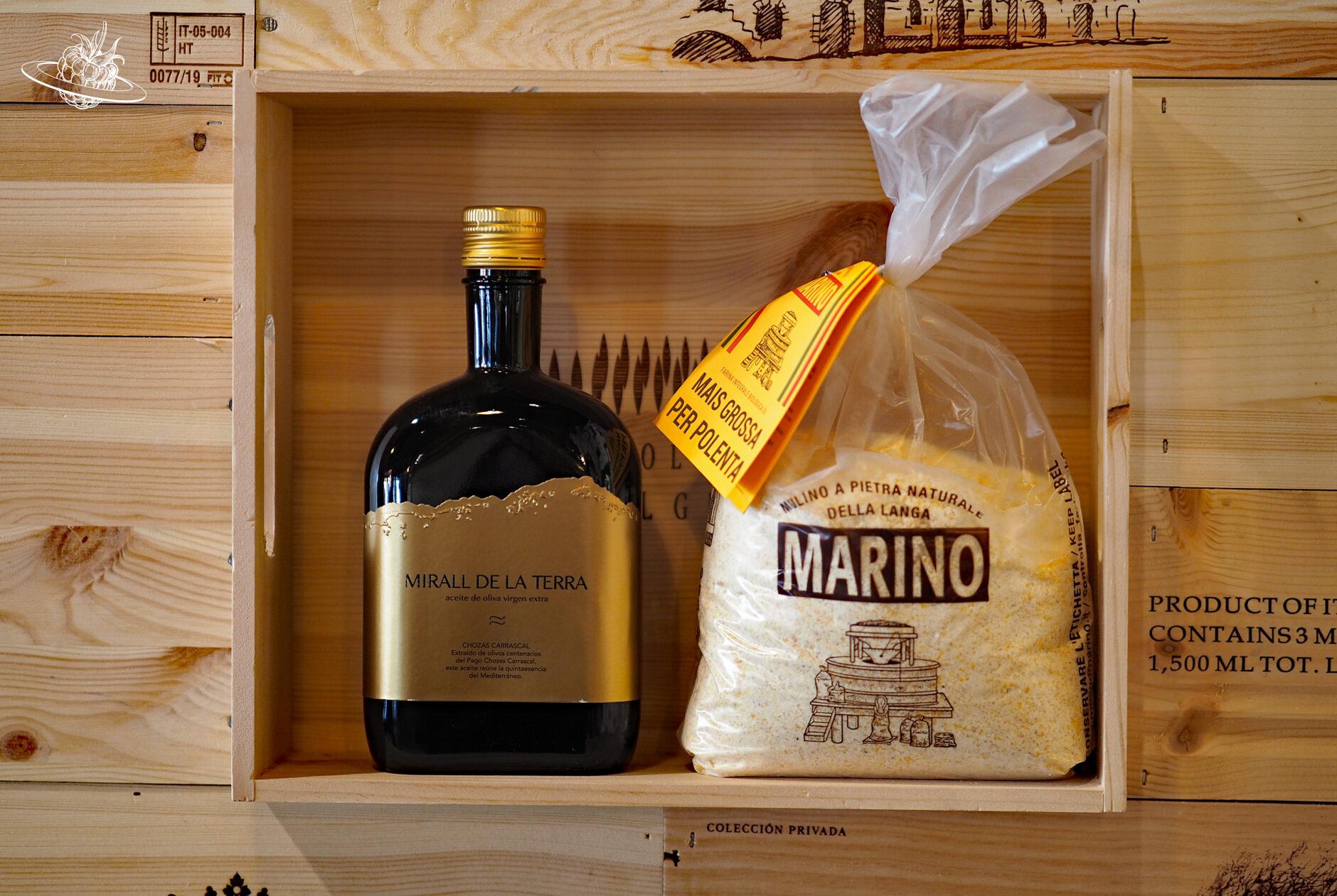 Als Dekoration aufgestellter Sack mit Polenta und eine Flasche Olivenöl