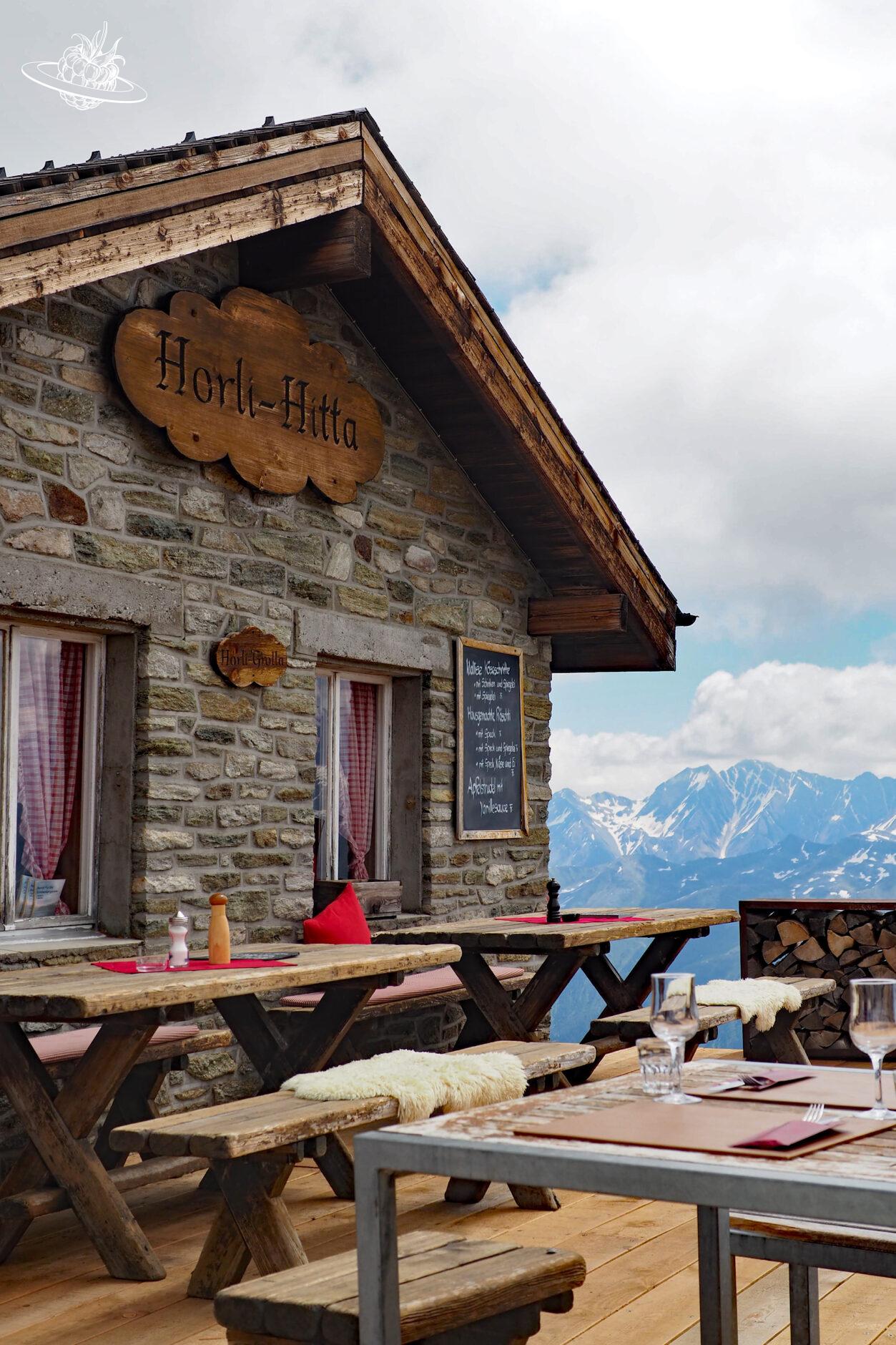 Kleine Berghütte mit Holztischen
