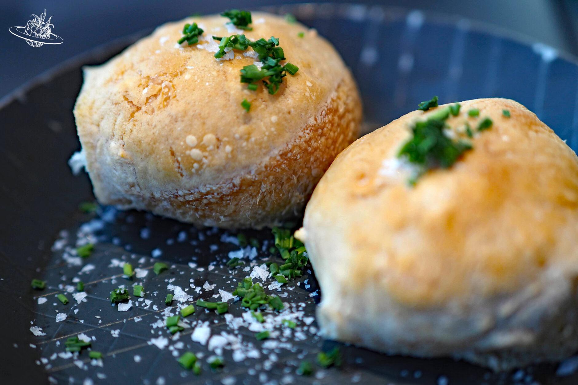 Zwei kleine Sauerteigbrötchen mit Salzflocken und Schnittlauch garniert