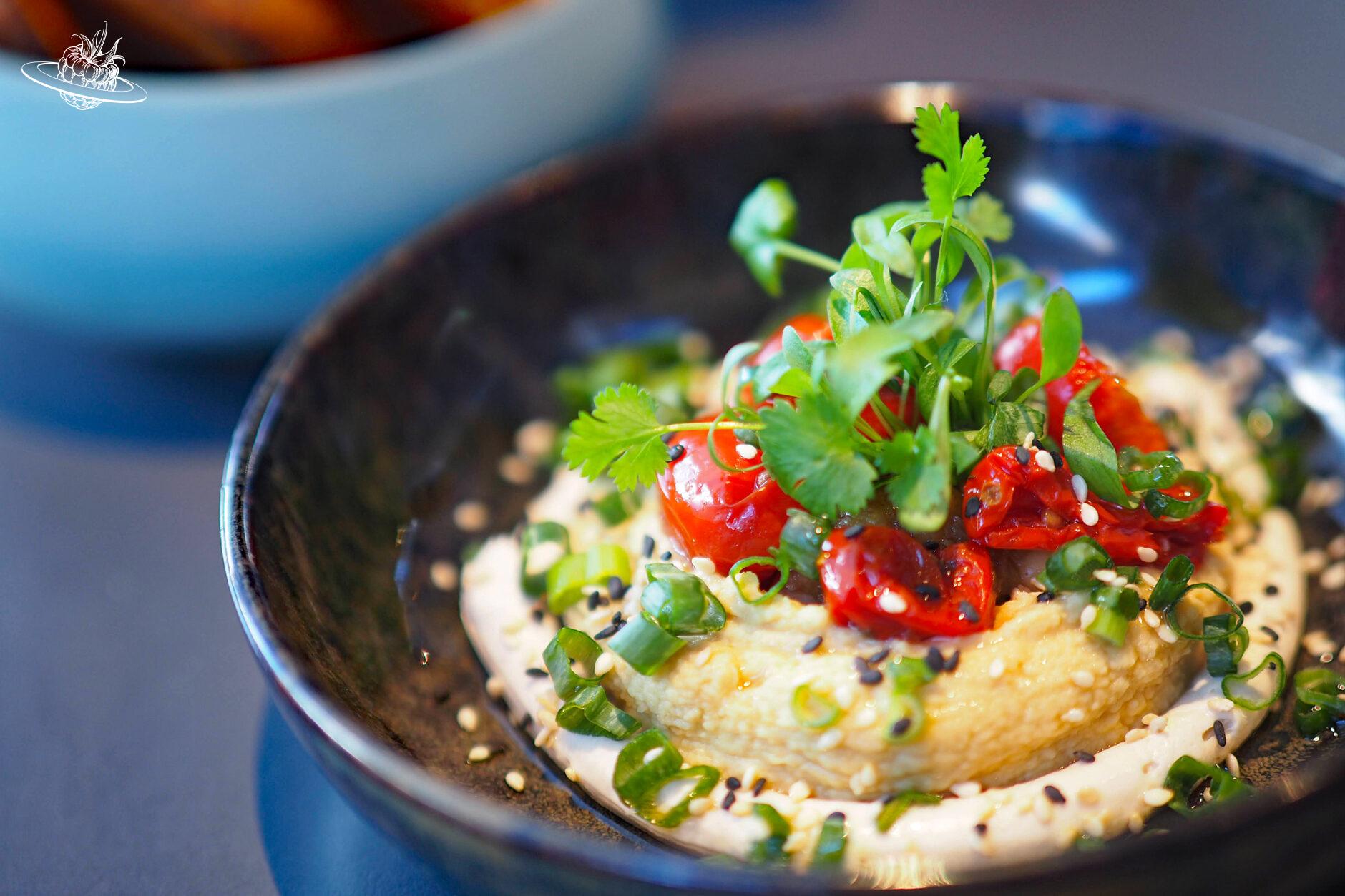 Hummus mit Tomaten und Kräuter dekoriert