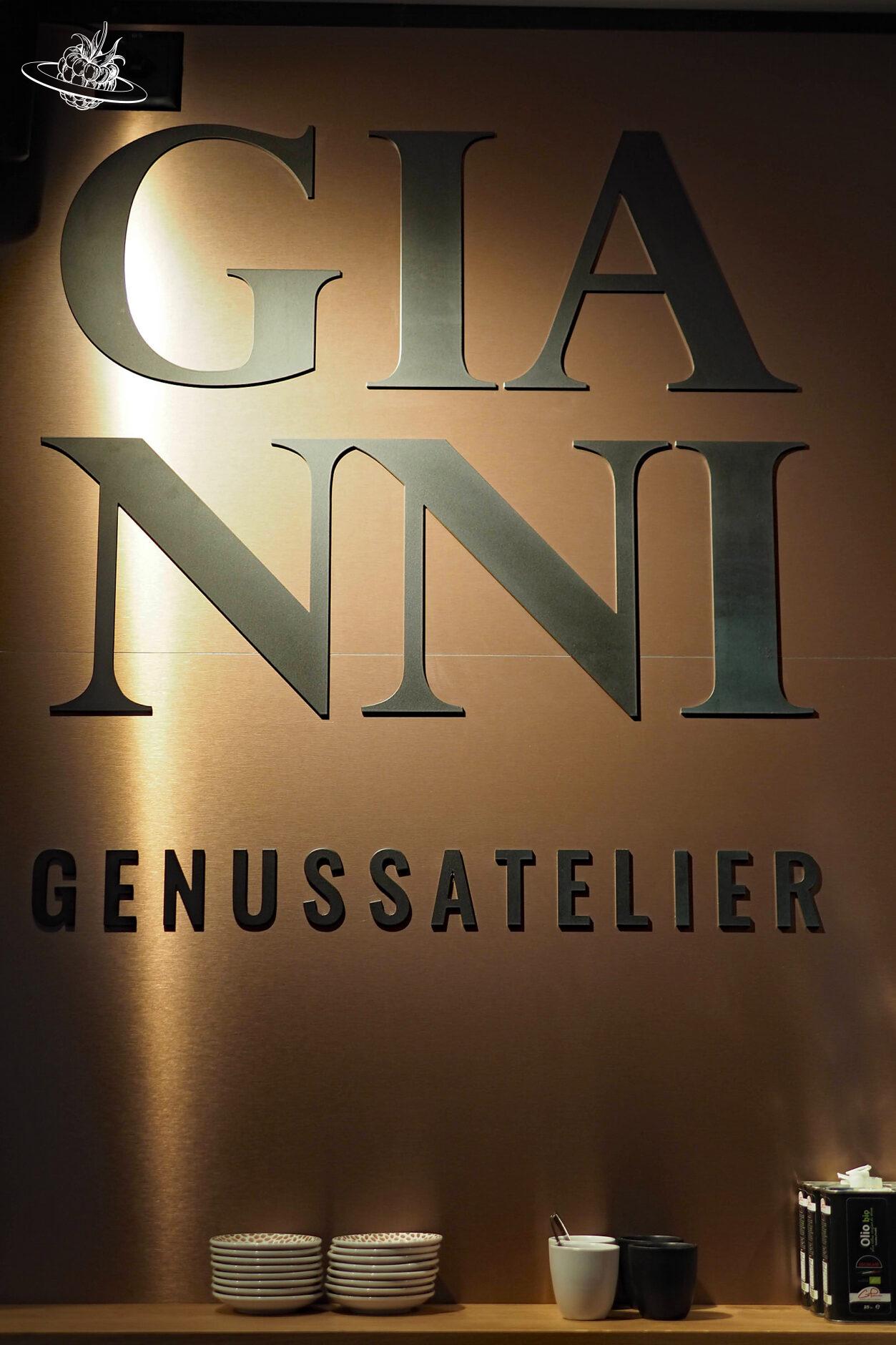 Grosser Schriftzug "Gianni Genussatelier" an der Wand