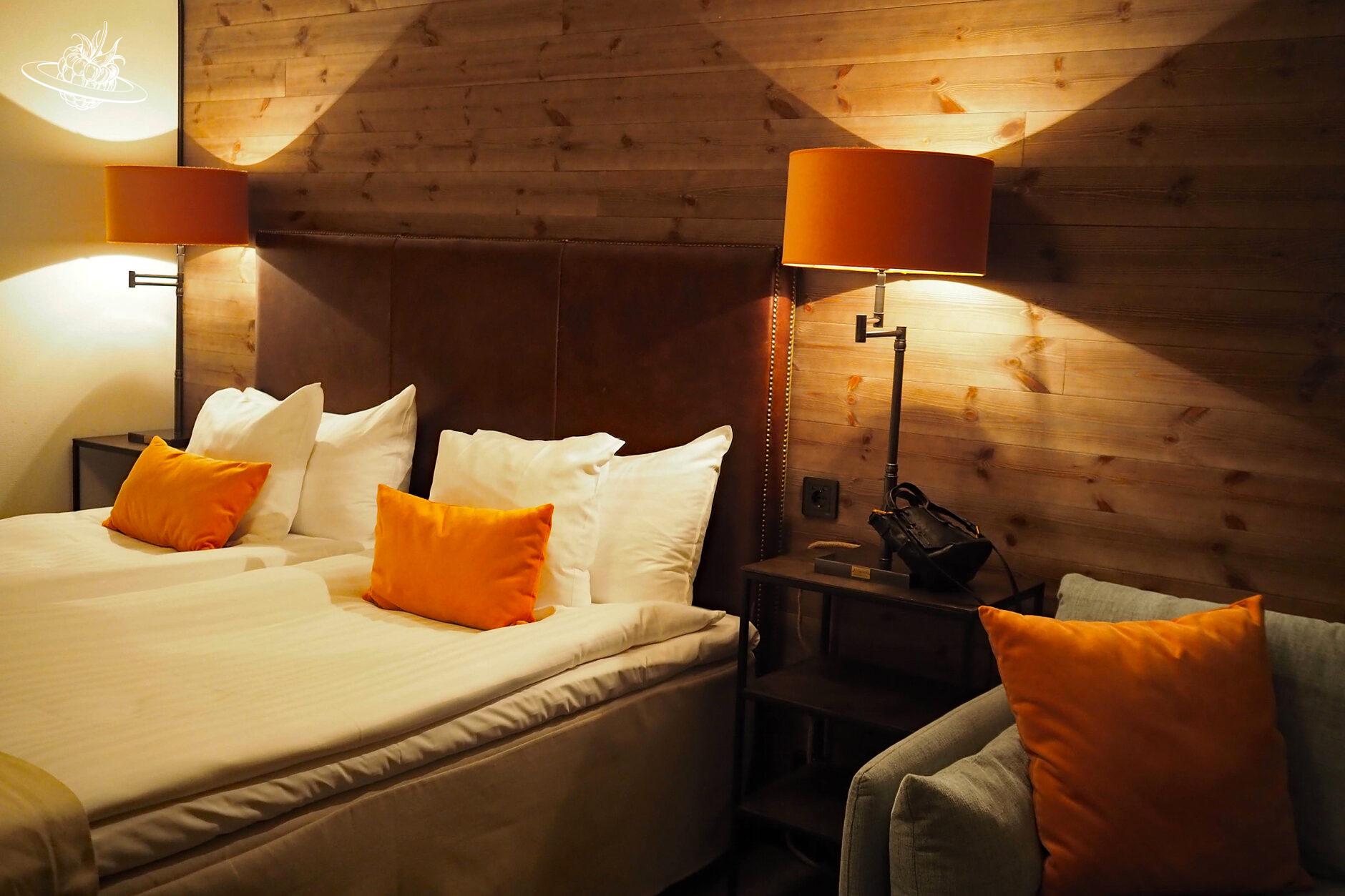 Hotelzimmer mit einem Doppelbett und orangen Kissen