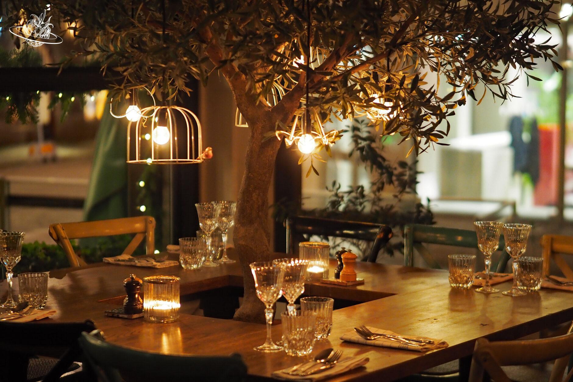 Tisch um einen Olivenbaum in einem Restaurant