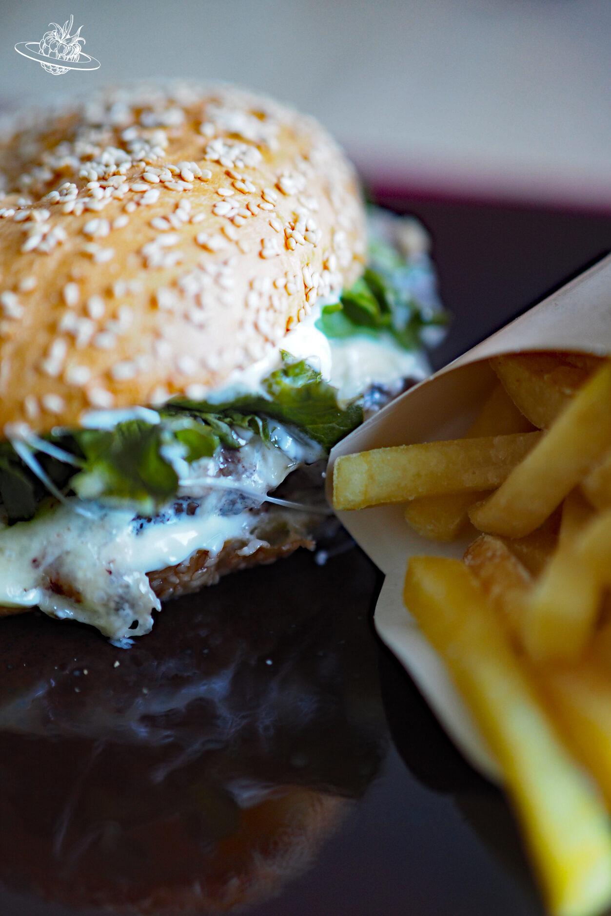 Ein Hamburger mit Käse und Pommes daneben