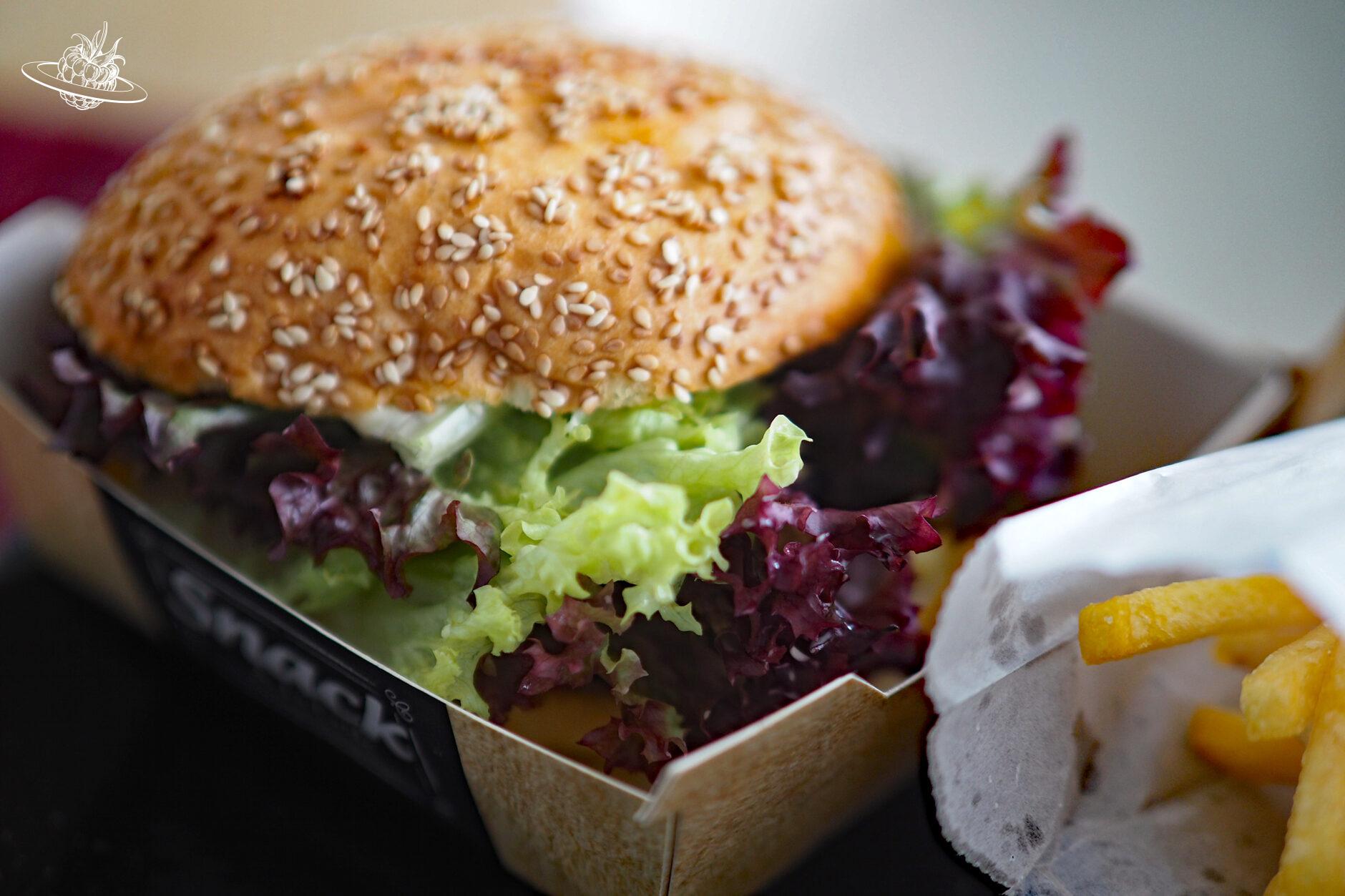 Ein Hamburger mit viel Salat in der Kartonbox
