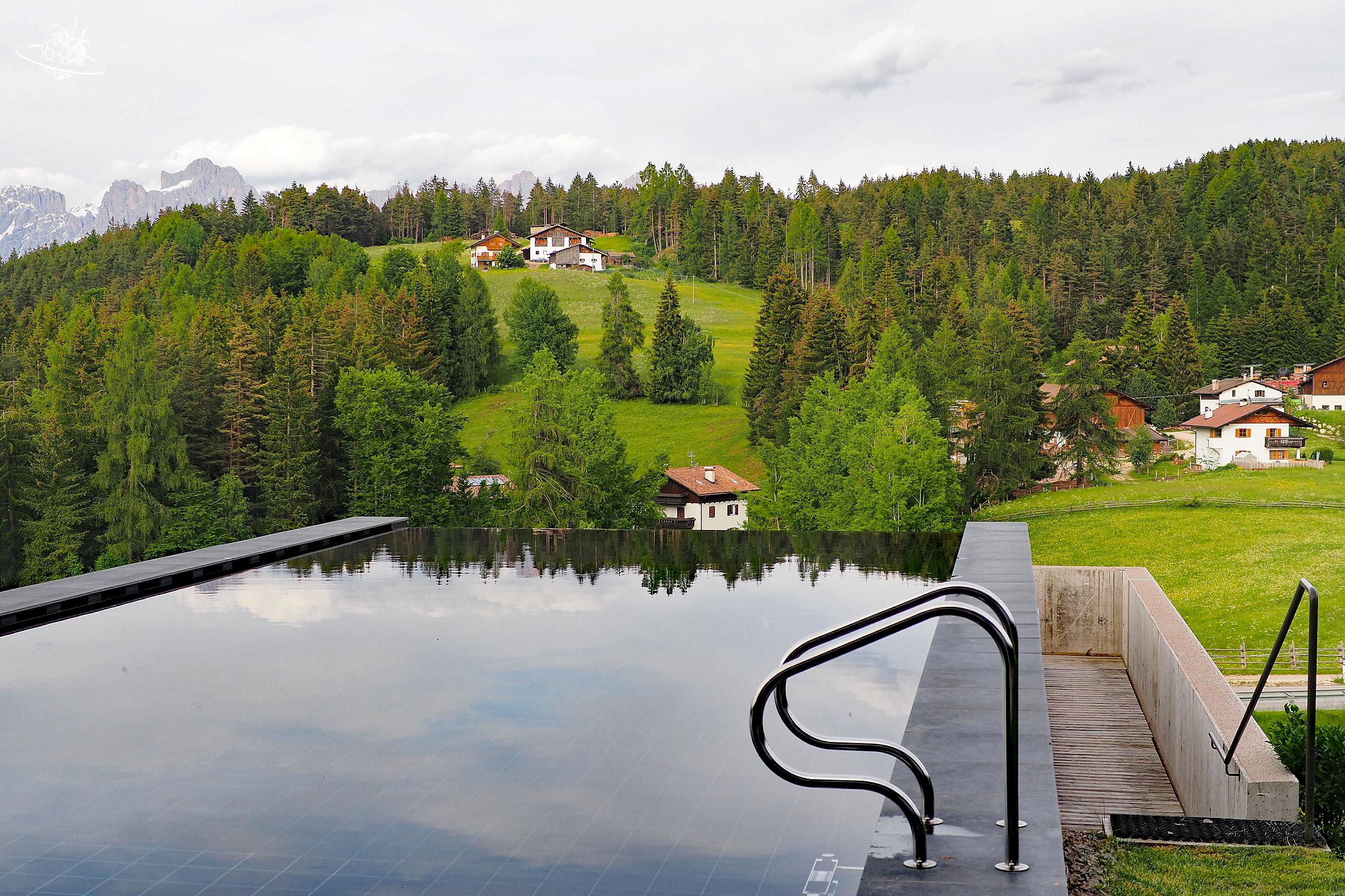 Ininitypool, in welchem sich der Wald im Hintergrund spiegelt