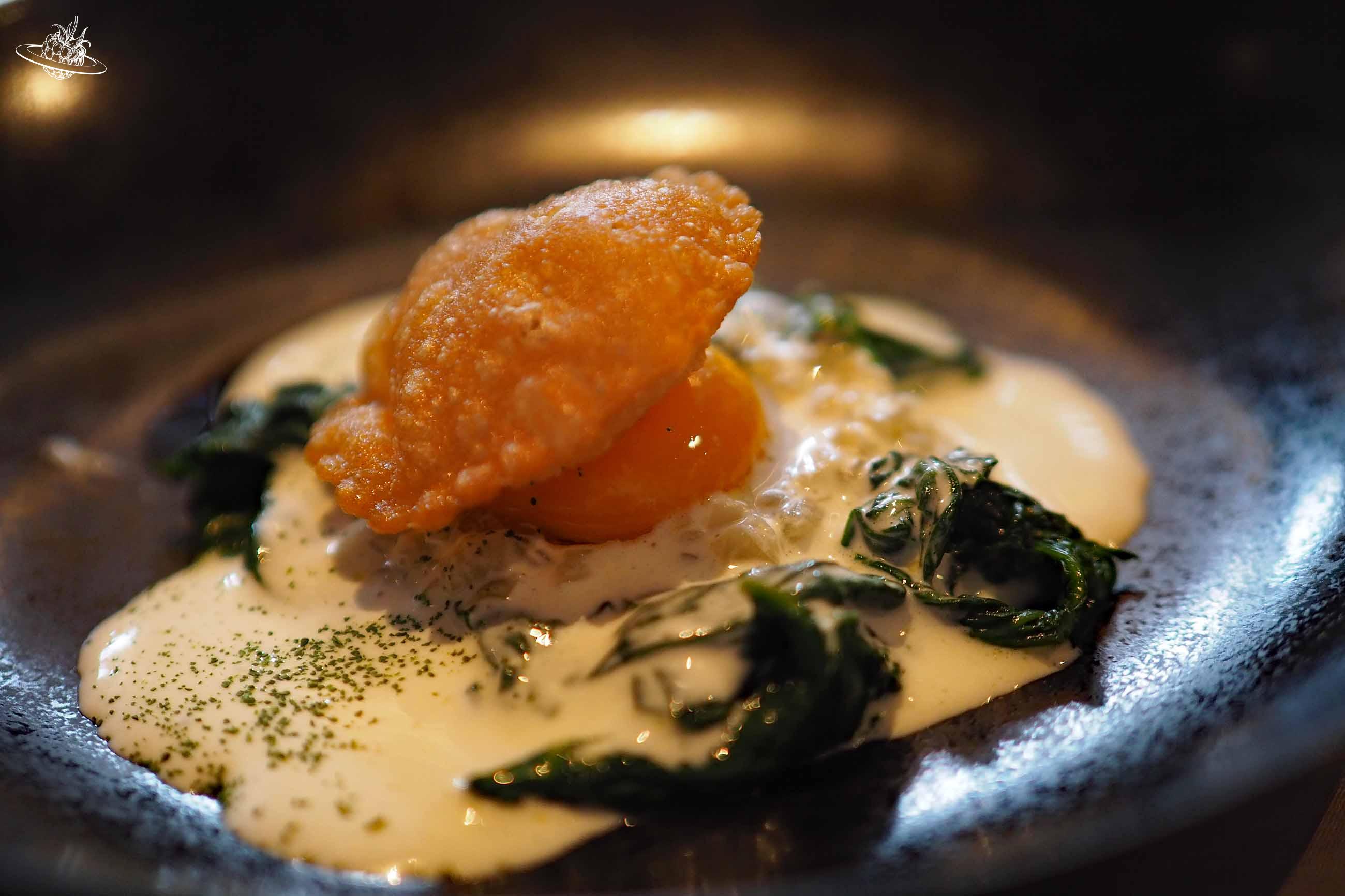 Gericht mit einem Ei auf weisser Sauce