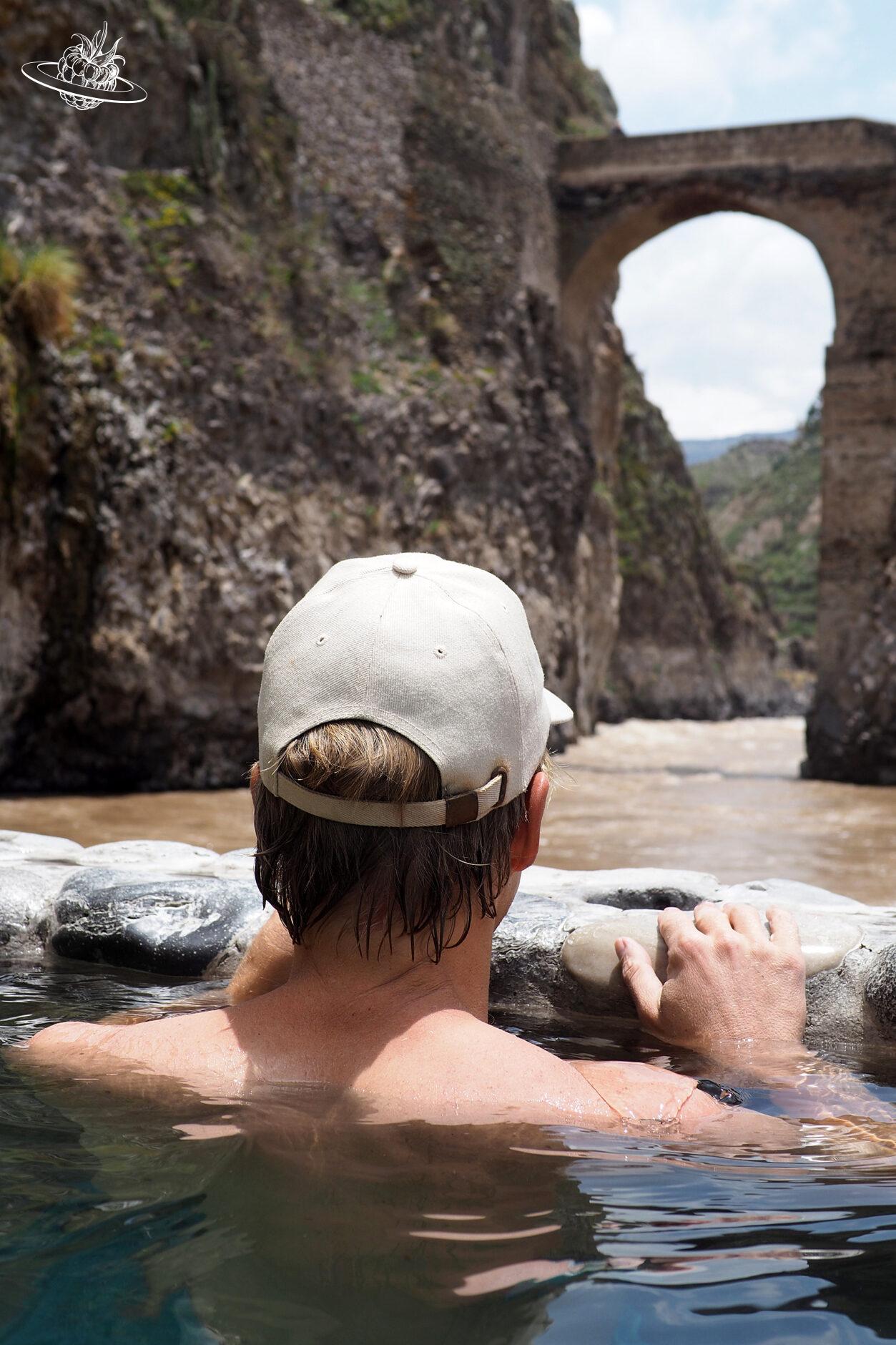Stefan im warmen Pool mit Blick auf den wilden Fluss