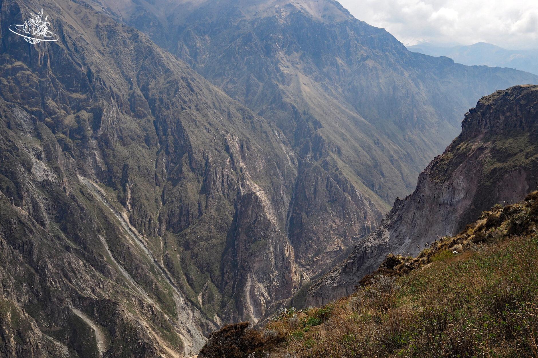 Blick in die tiefe Schlucht, umgeben von hohen Bergen