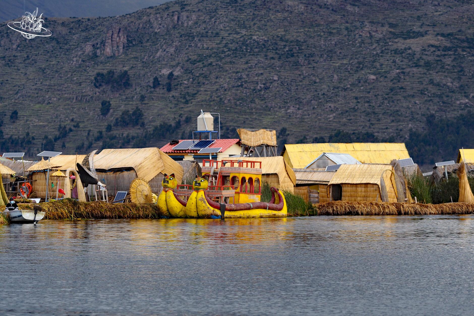 Verschiedene Hütten und ein grosses Boot am Titicacasee
