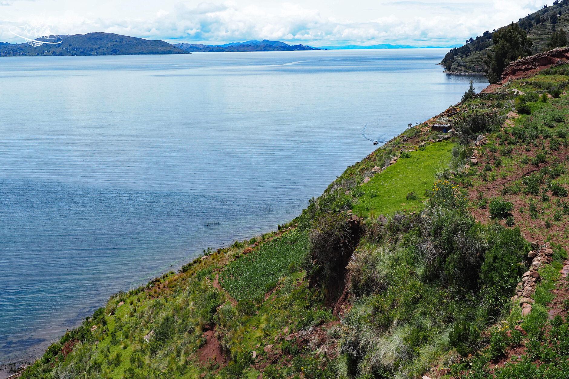 Grünes, steil abfallendes Ufer zum See der Insel Taquile
