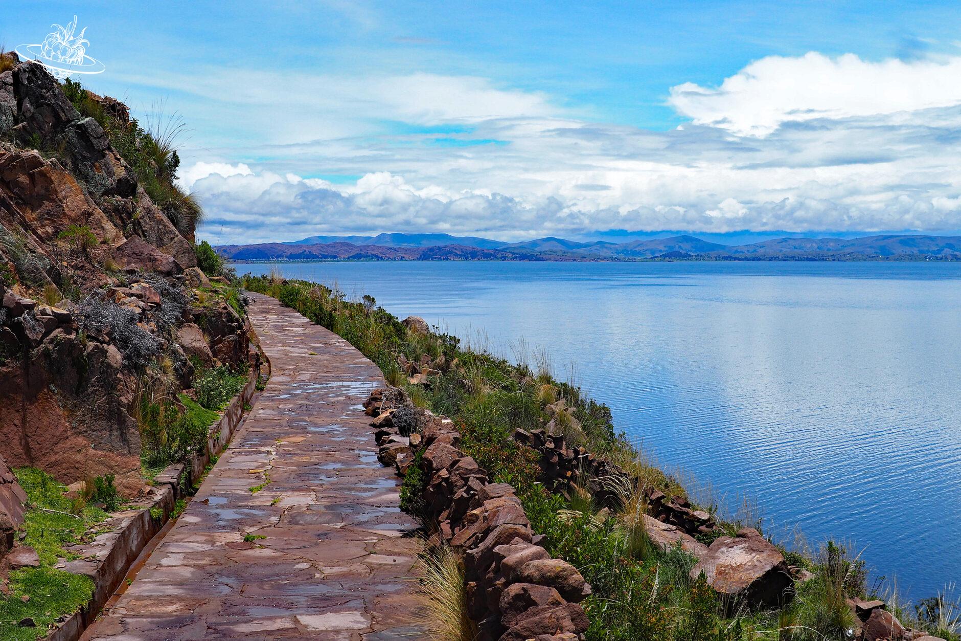 Gepflasterter Wanderweg mit dem Titicacasee im Hintergrund