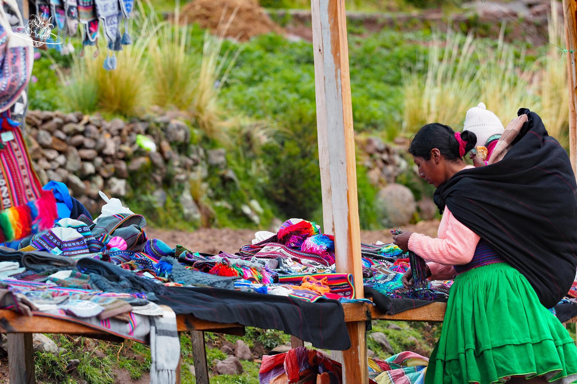 frau mit kind auf dem rücken am marktstand