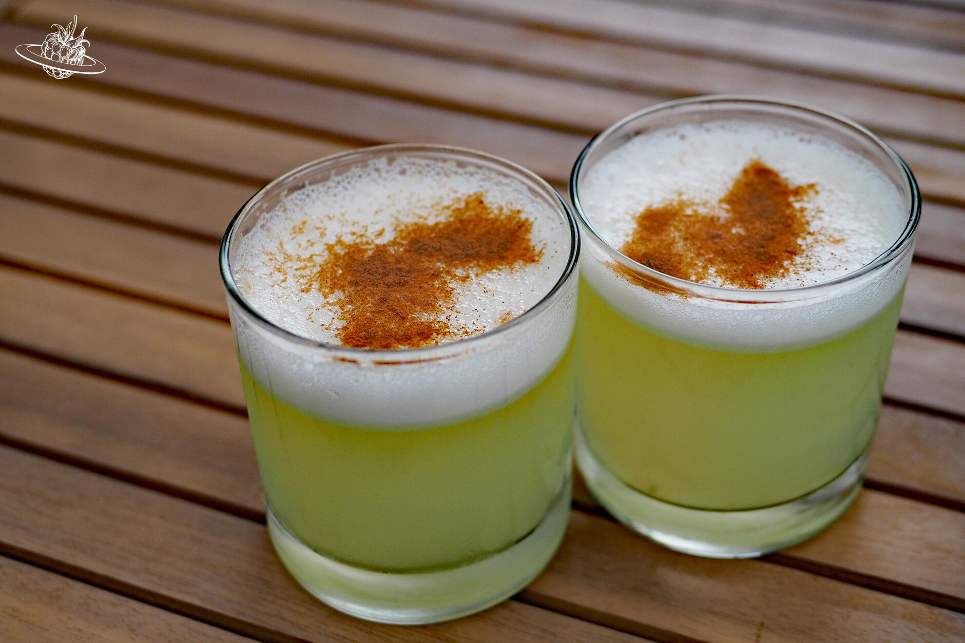 zwei gläser mit alkohol und zimt obendrauf