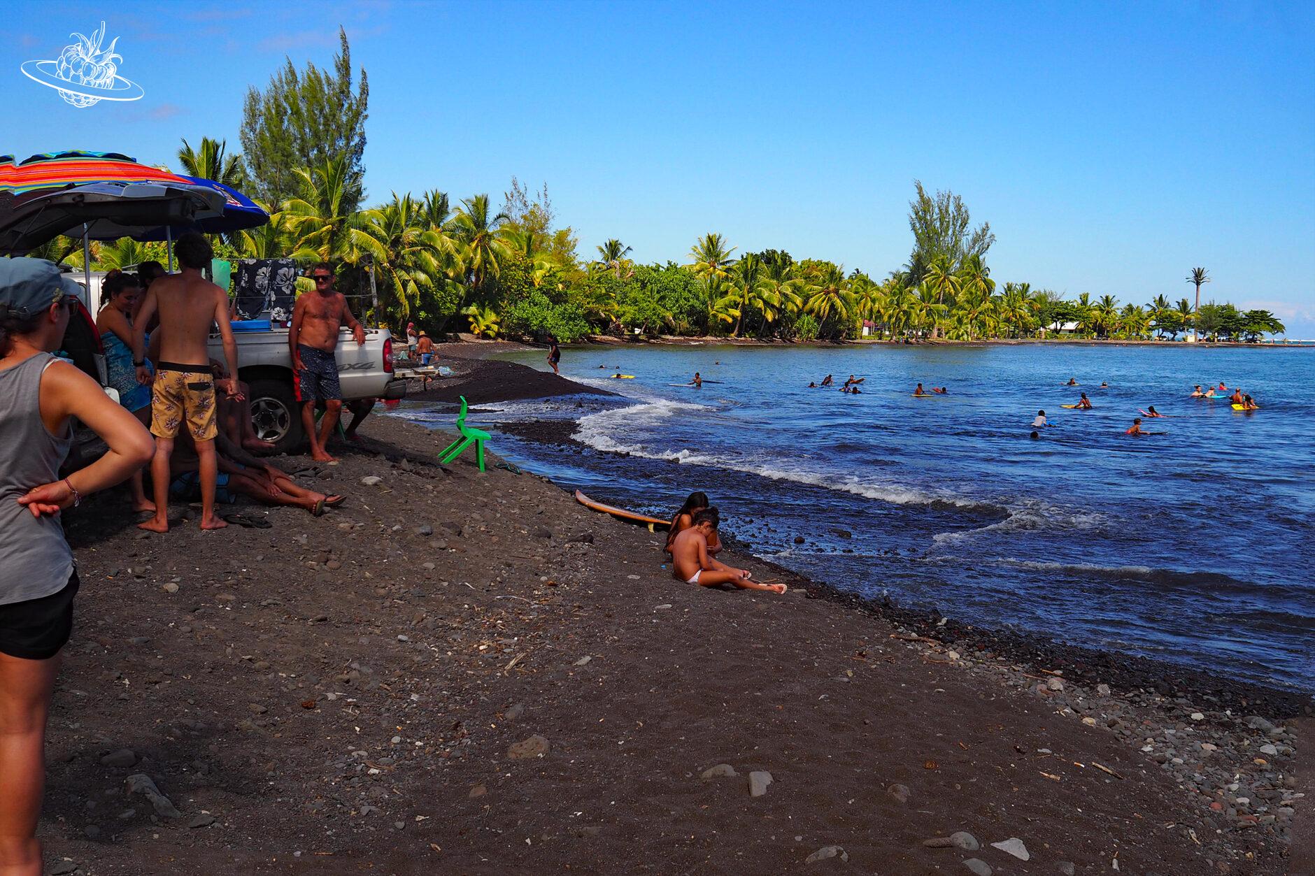 schwarzer strand mit ein paar leuten