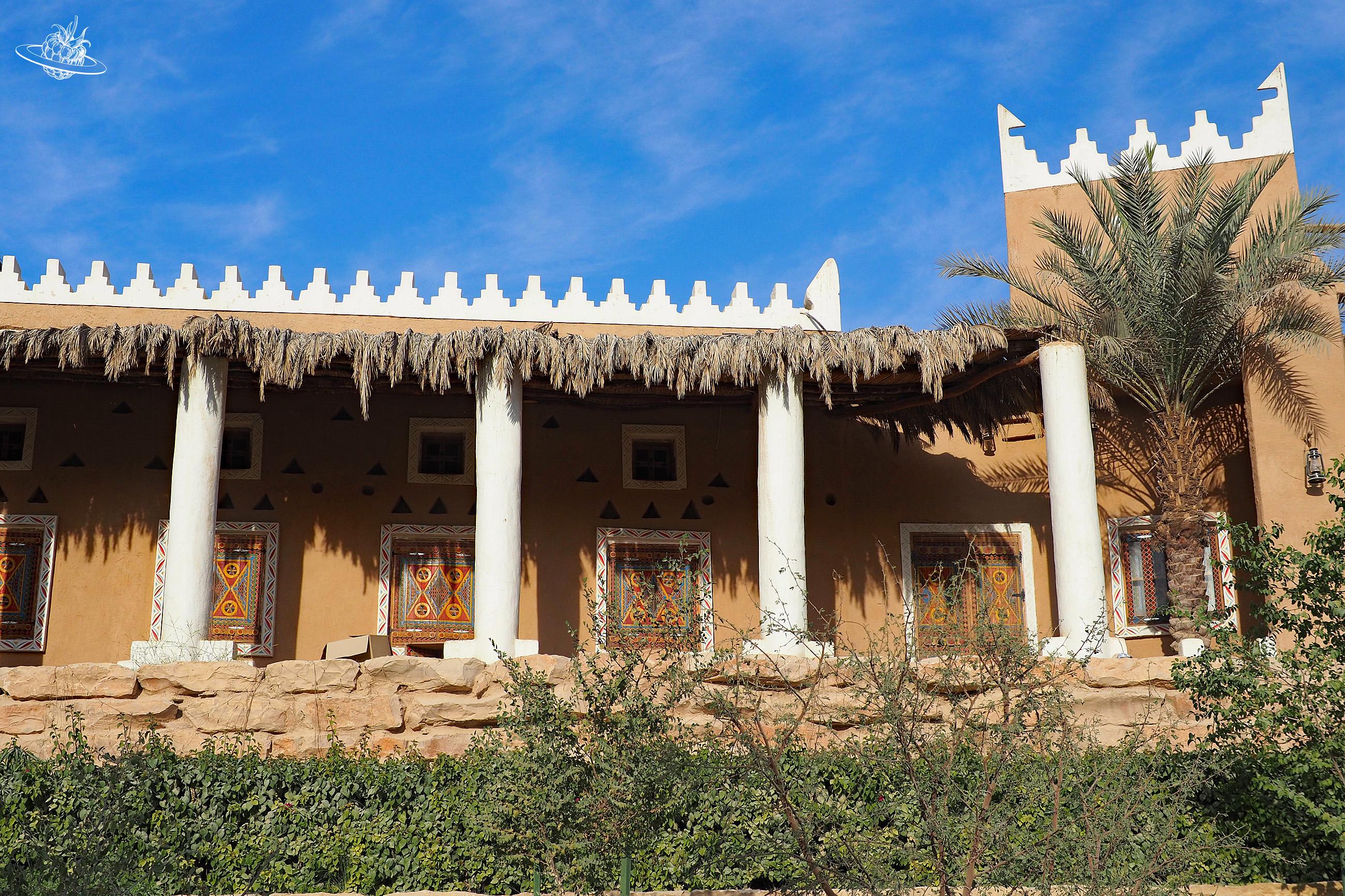 Lehmbaute mit einer Palme umgeben