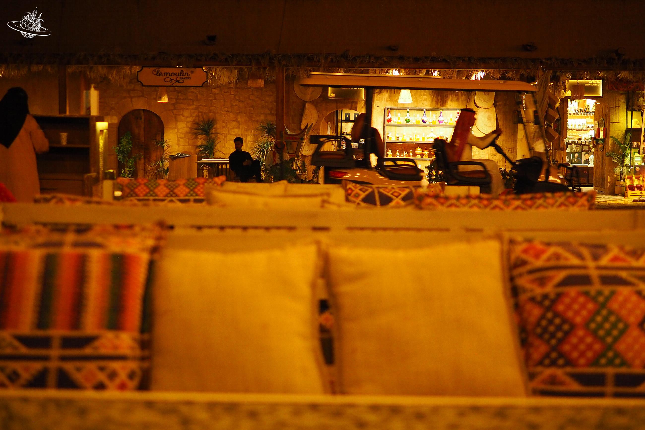 Sitzbänke mit Kissen und im Hintergrund reges Treiben