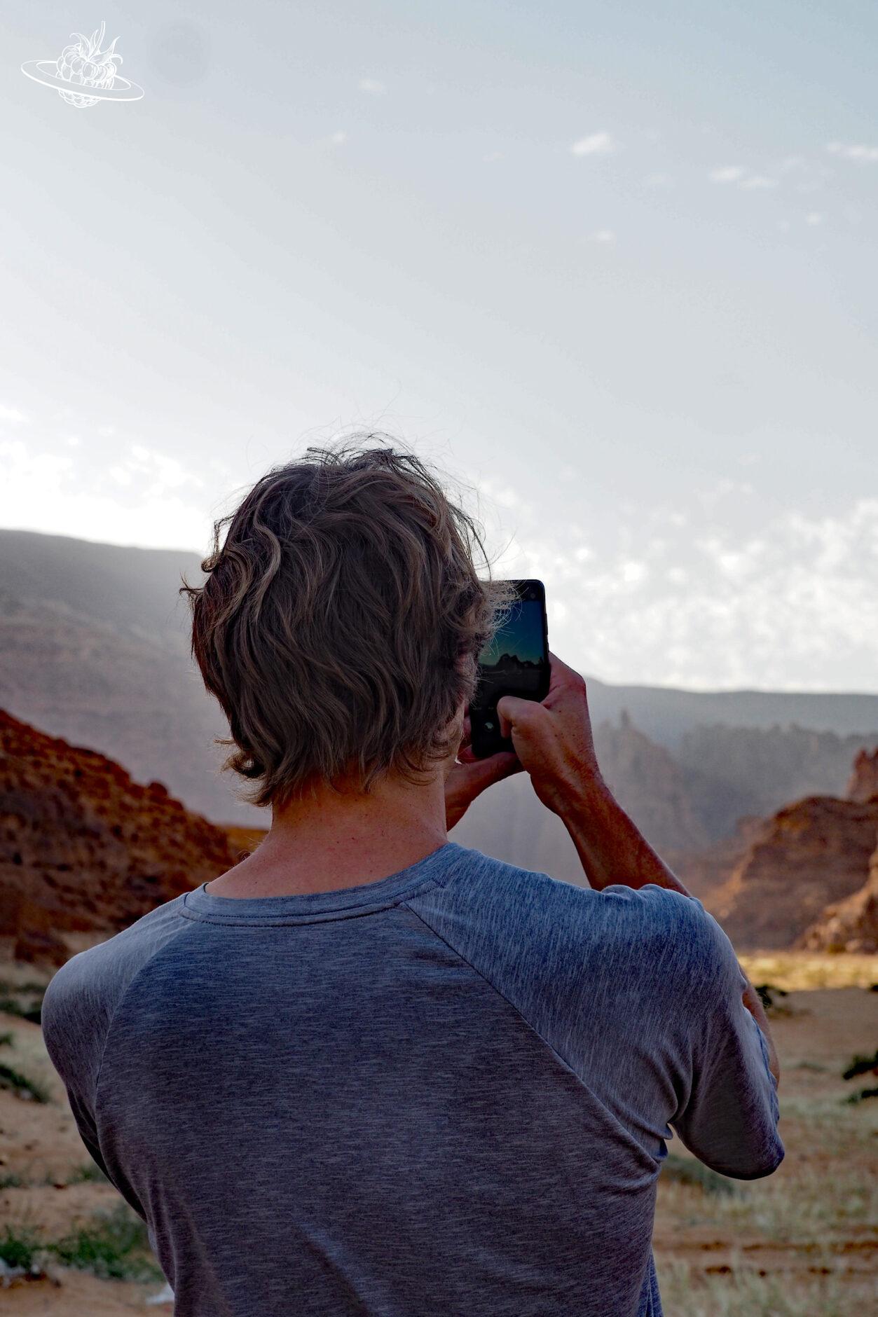 Mann fotografiert mit Handy Felsgesteine