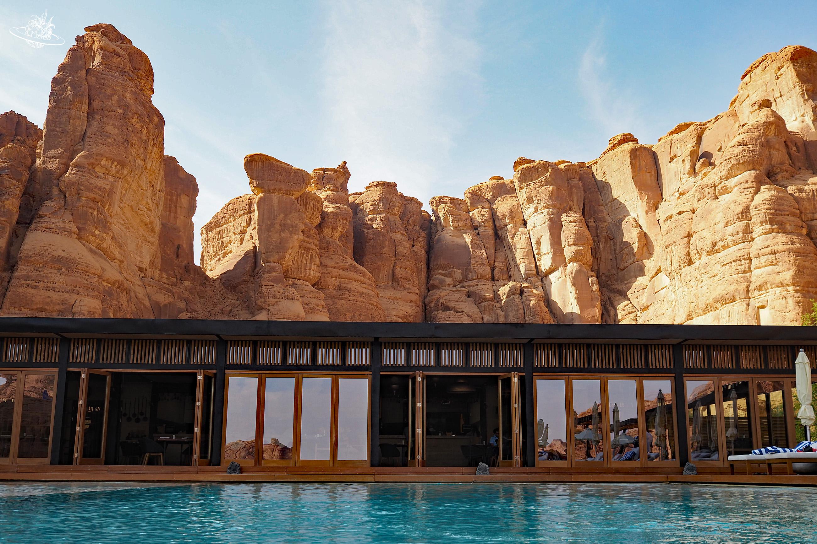 pool mit restaurant und felsformation im hintergrund