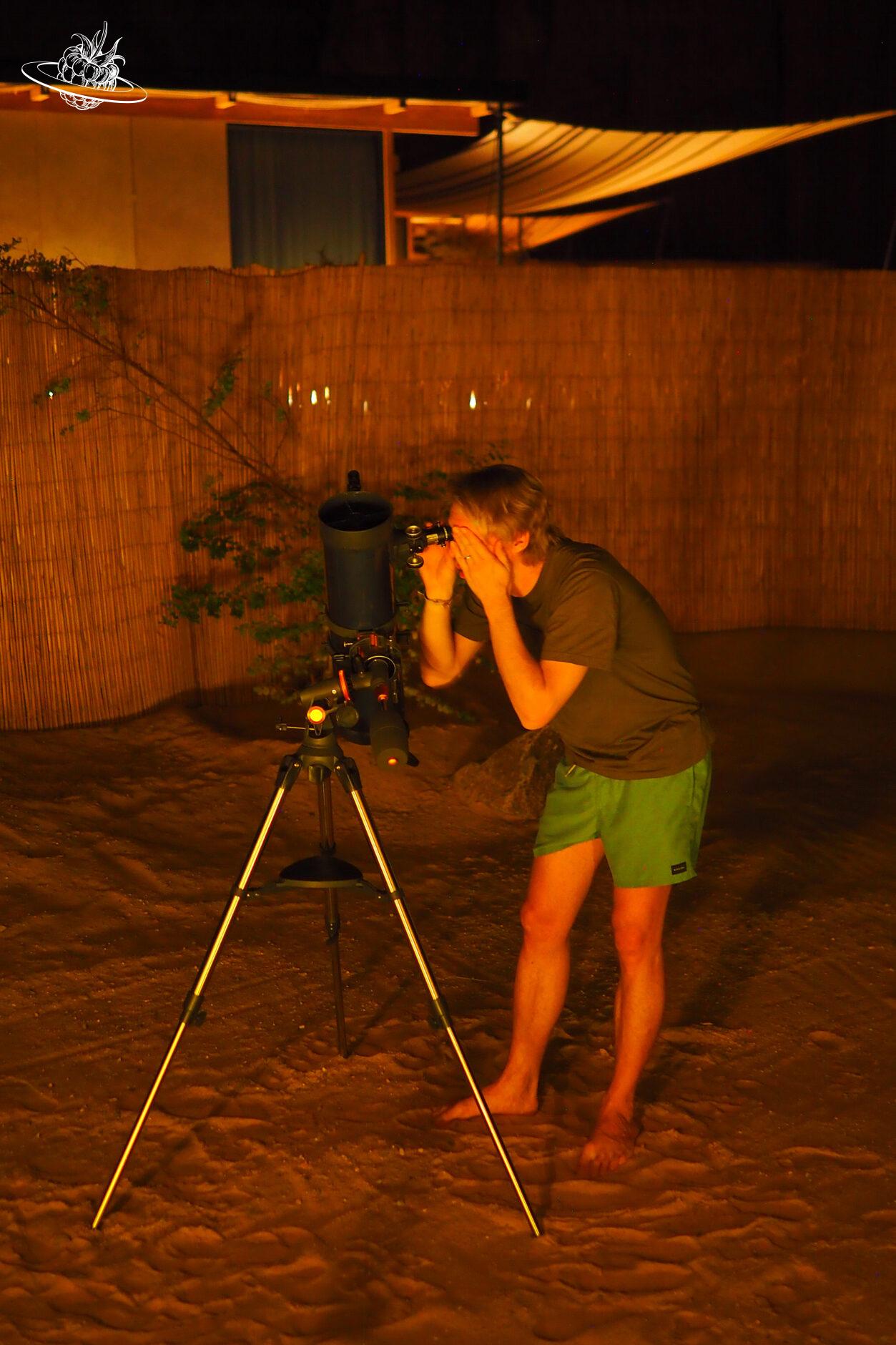 Mann schaut durchs Teleskop