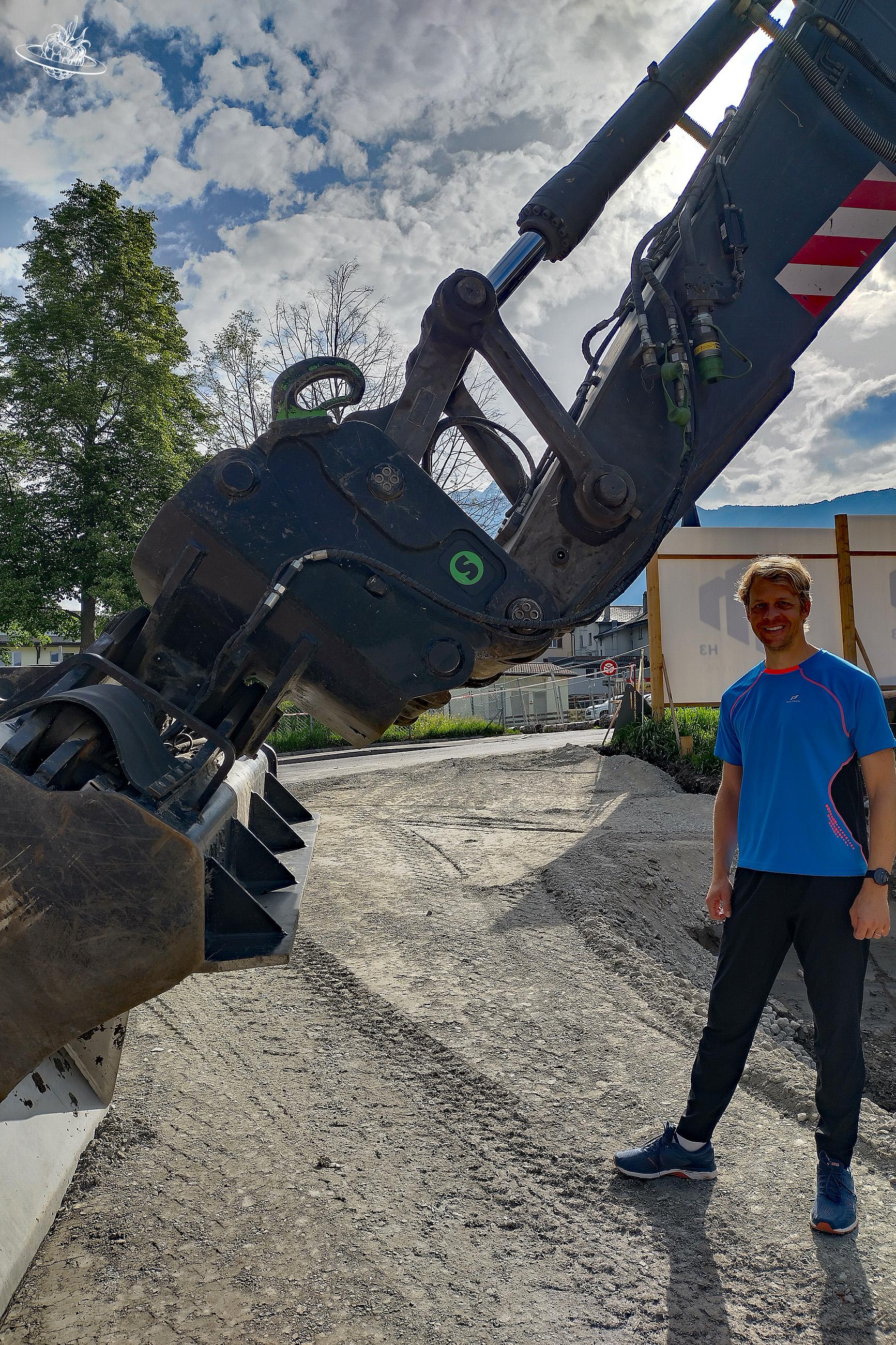 Mann stehend unter dem Bagger