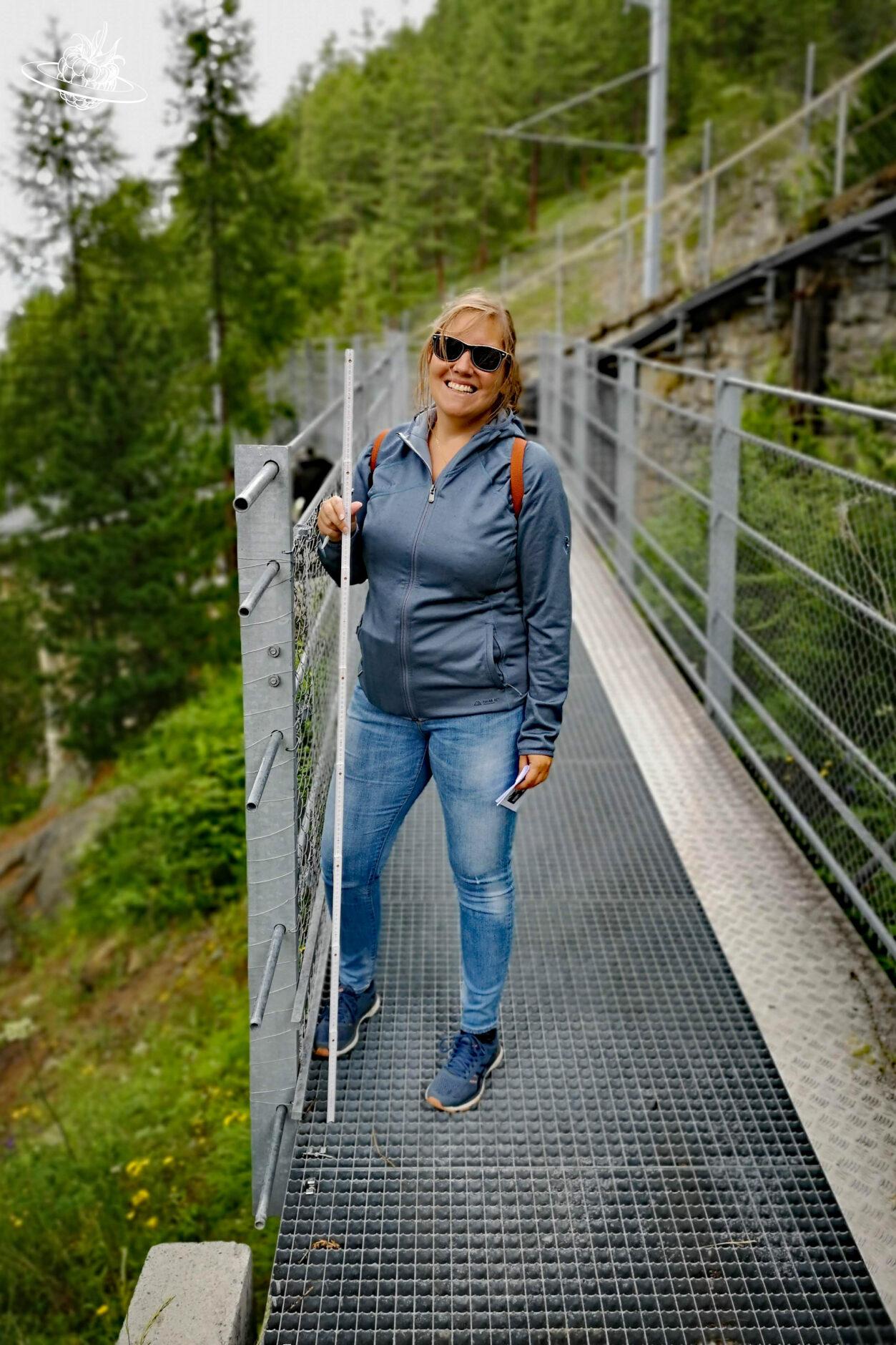 Frau mit Meter auf Wanderweg am arbeiten
