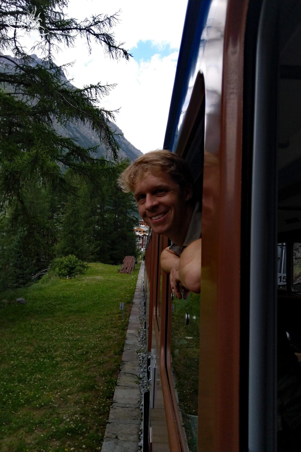 Mann lehnt sich aus dem Zugfenster