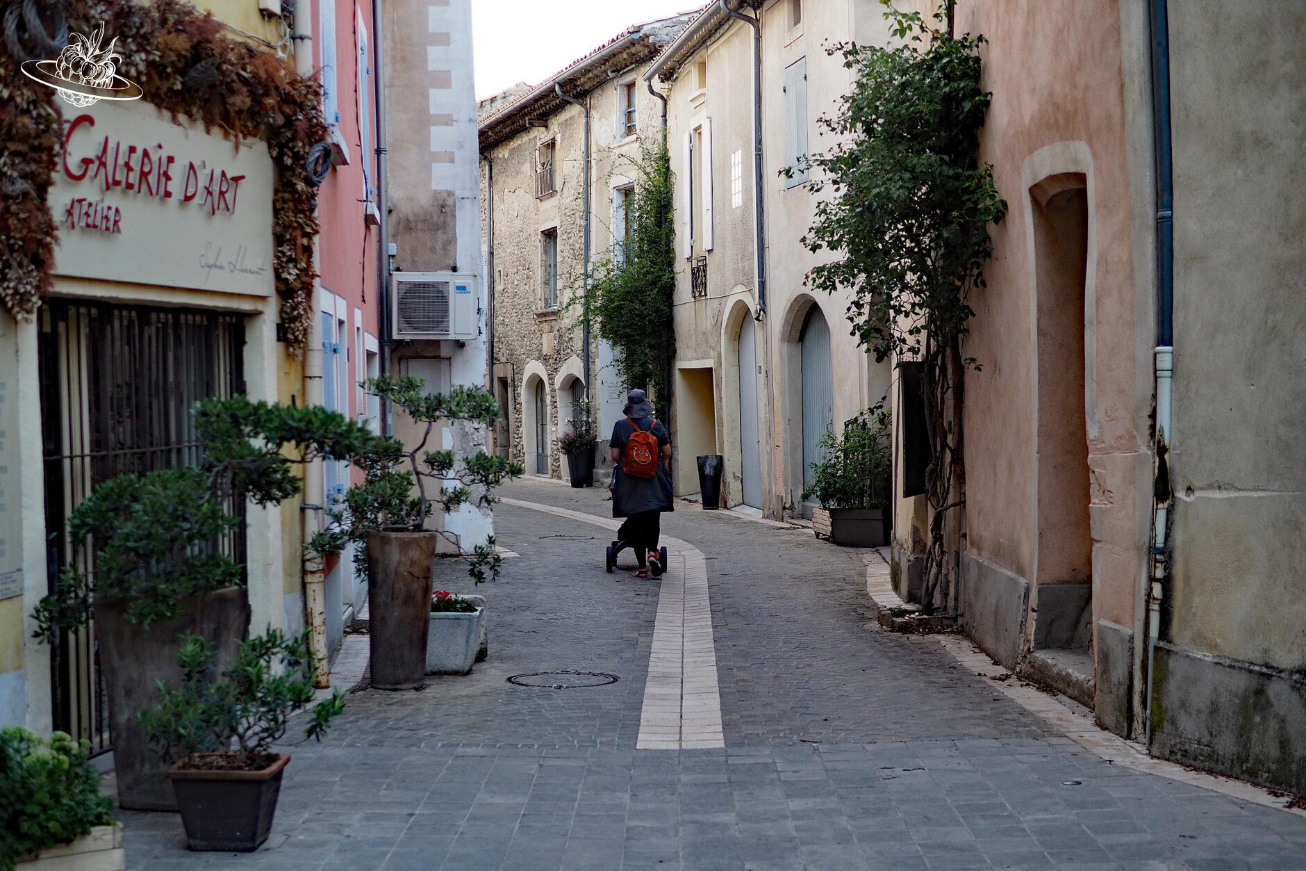 Frau mit Kinderwagen durch Gasse