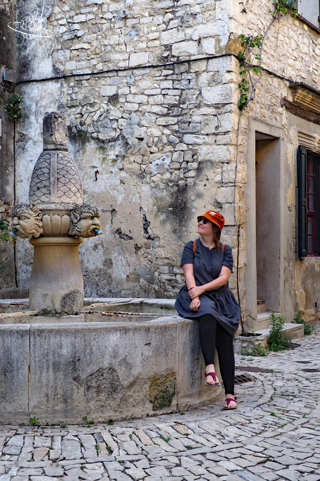frau sitzt auf brunnenrand