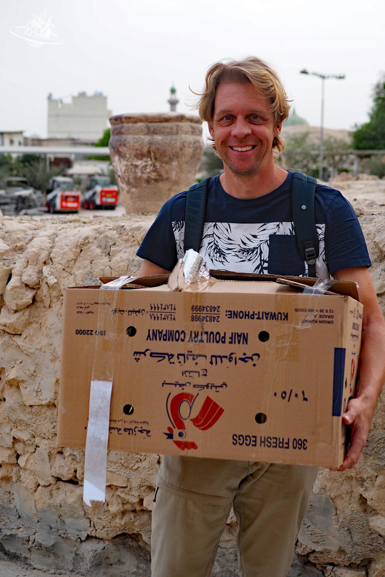 Mann trägt grosse Kiste