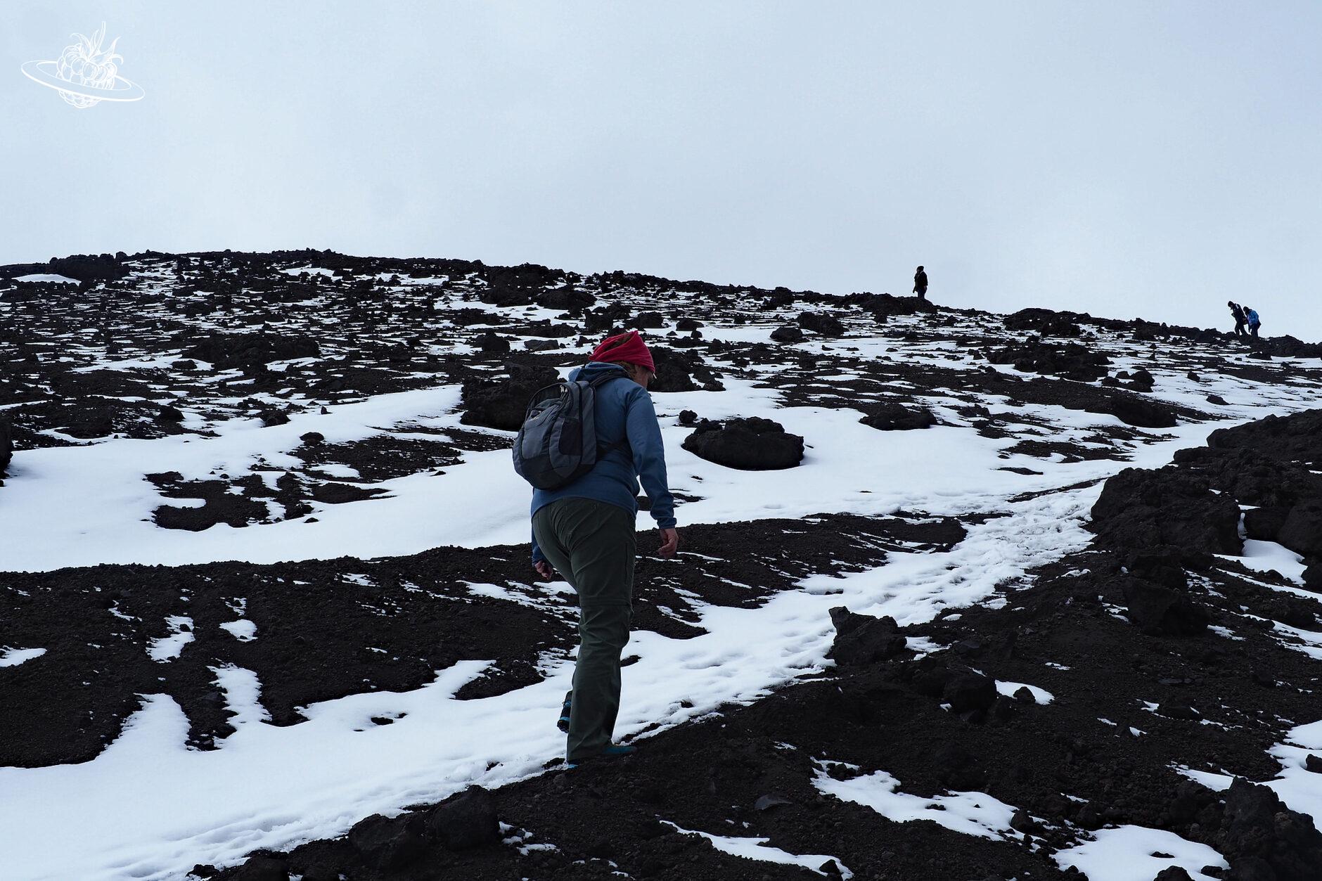 Frau läuft auf Berg mit Matsch und Eis