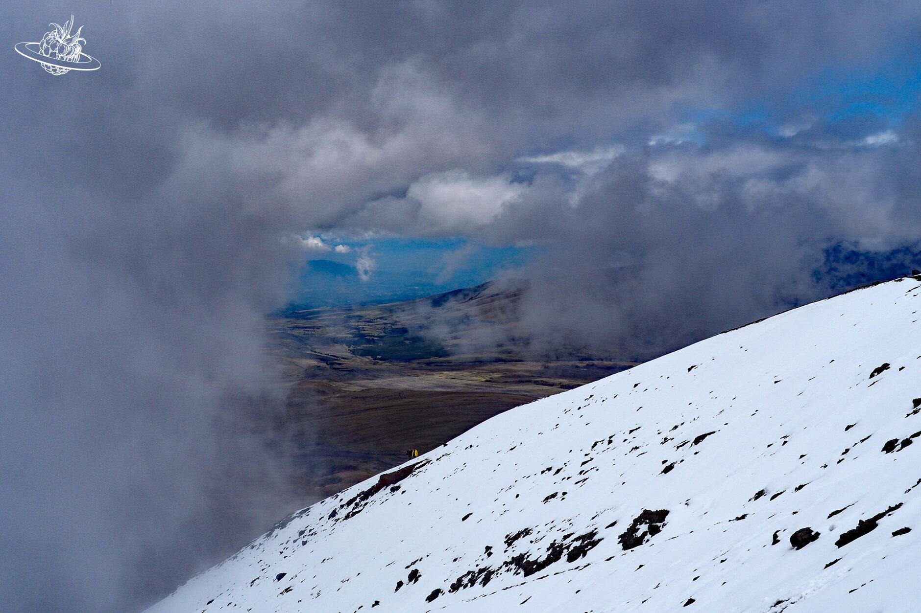 Schneebedeckter Vulkan im Nebel, welcher sich öffnet
