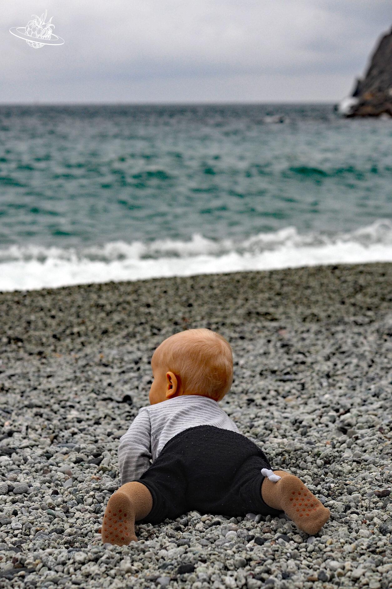 Kleinkind am Kieselstrand beim Meer