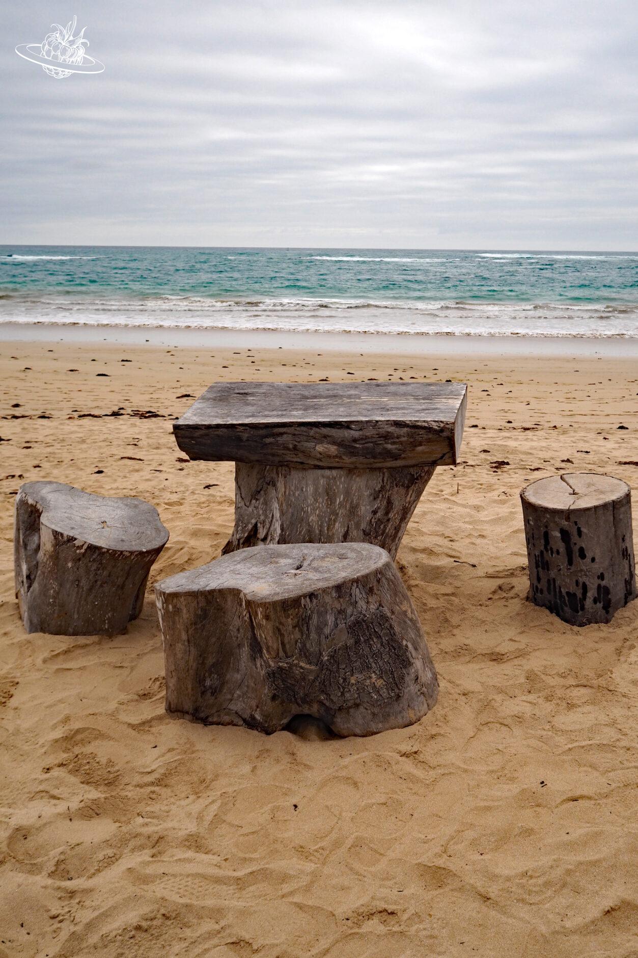 Holztisch und Stuhl am Meer