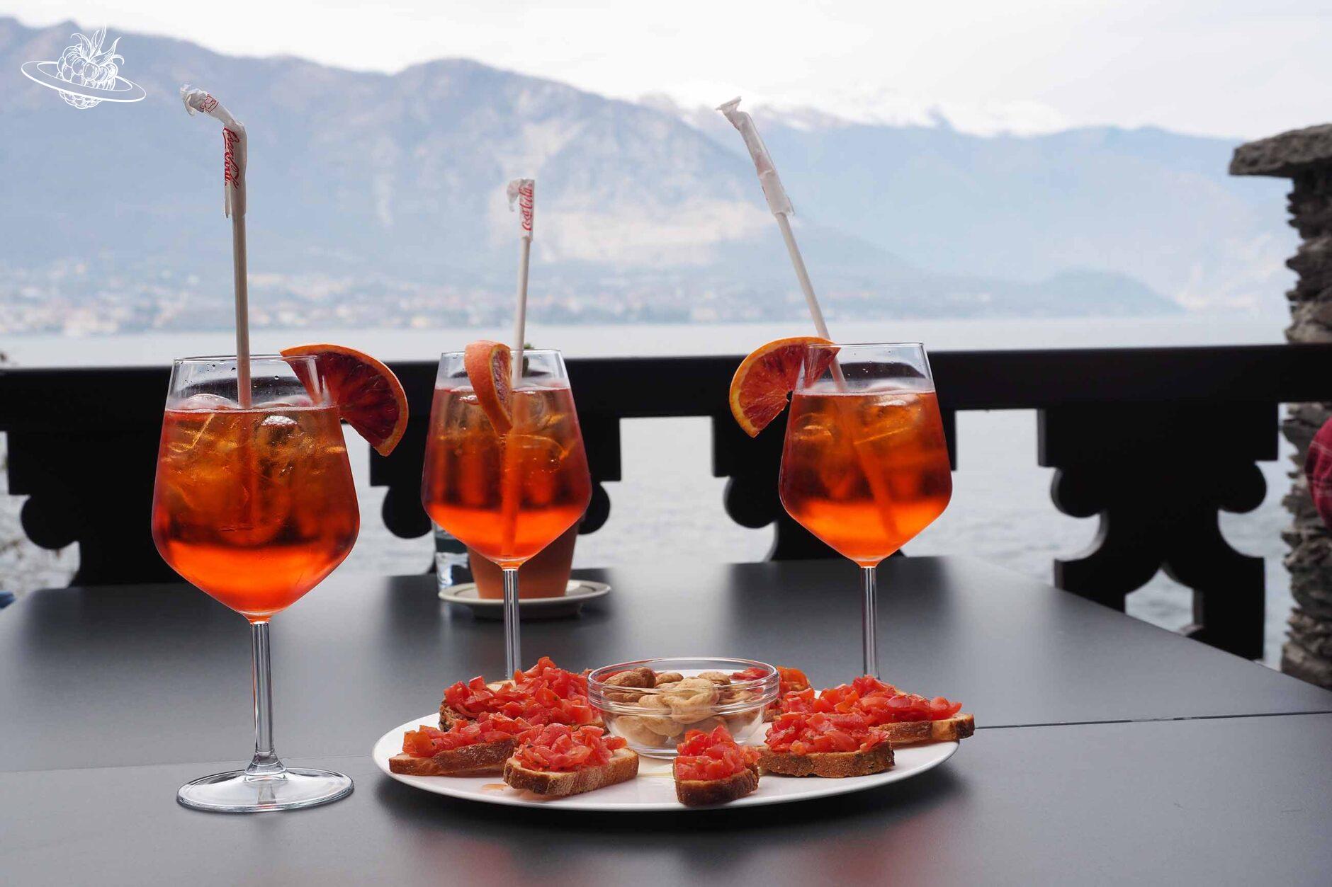 Drei Gläser mit Aperol Spritz und einem kleinen Aperoteller