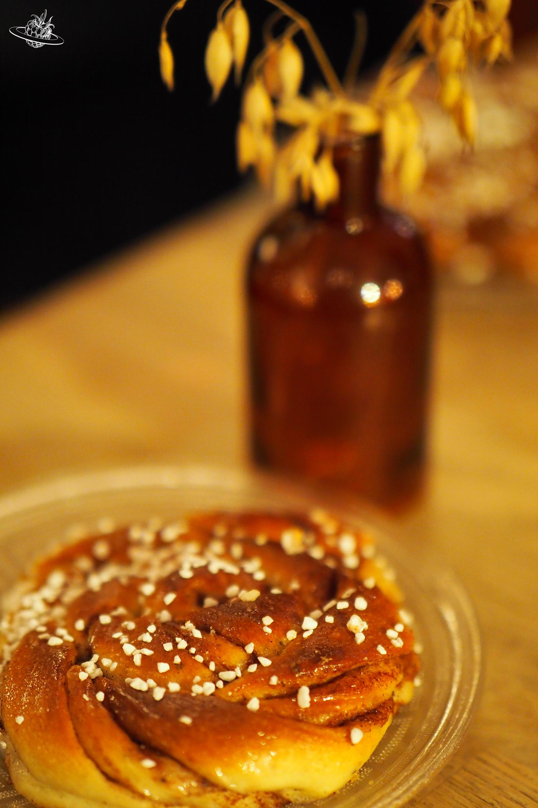 Zimtschnecke und im Hintergrund steht eine Vase