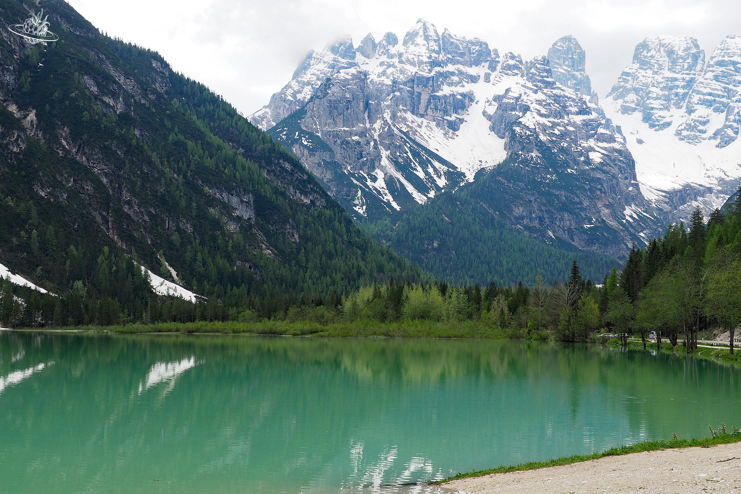 grüner Bergsee mit Bergen im Hintergrund