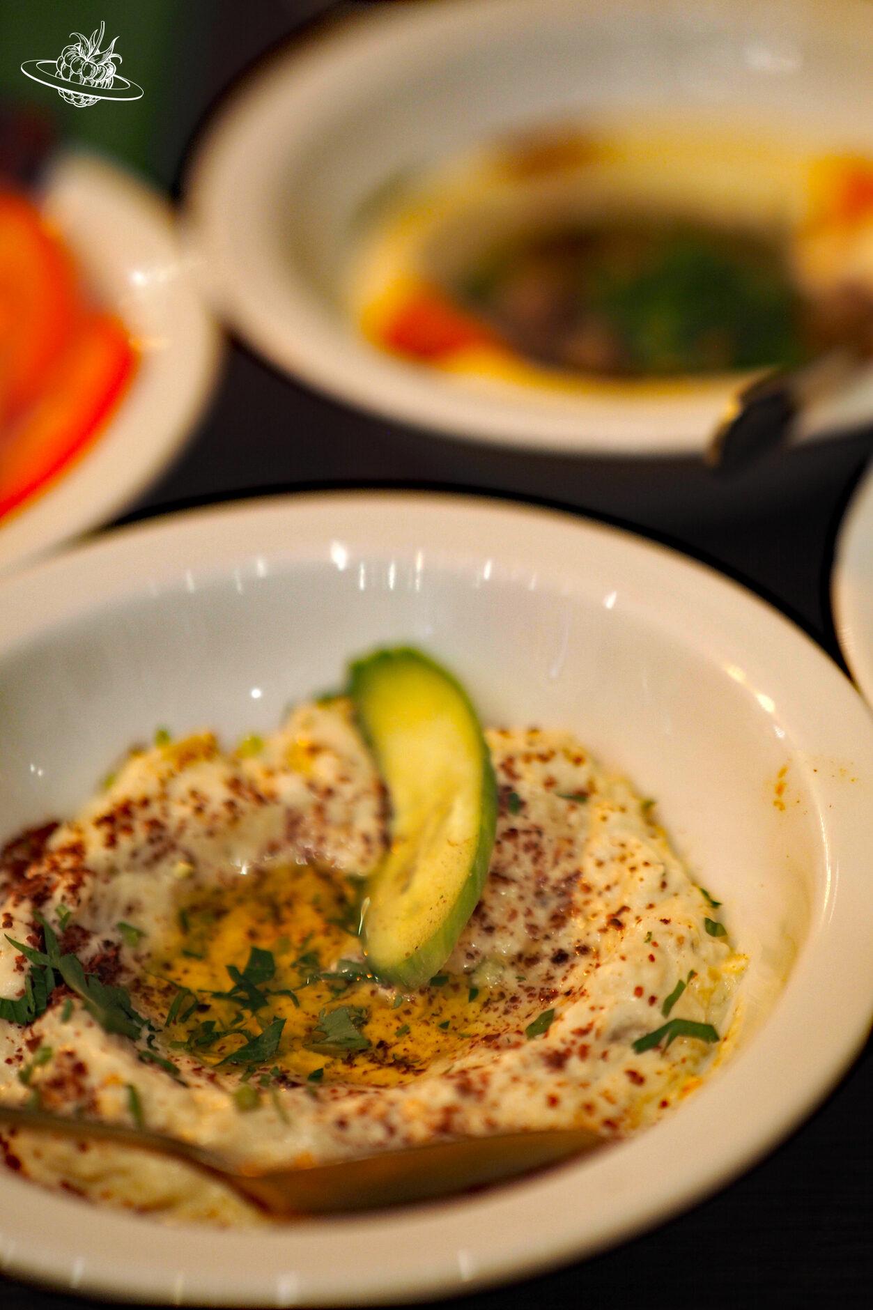 Hummus und verschiedene kleine Teller mit diversen Inhalten