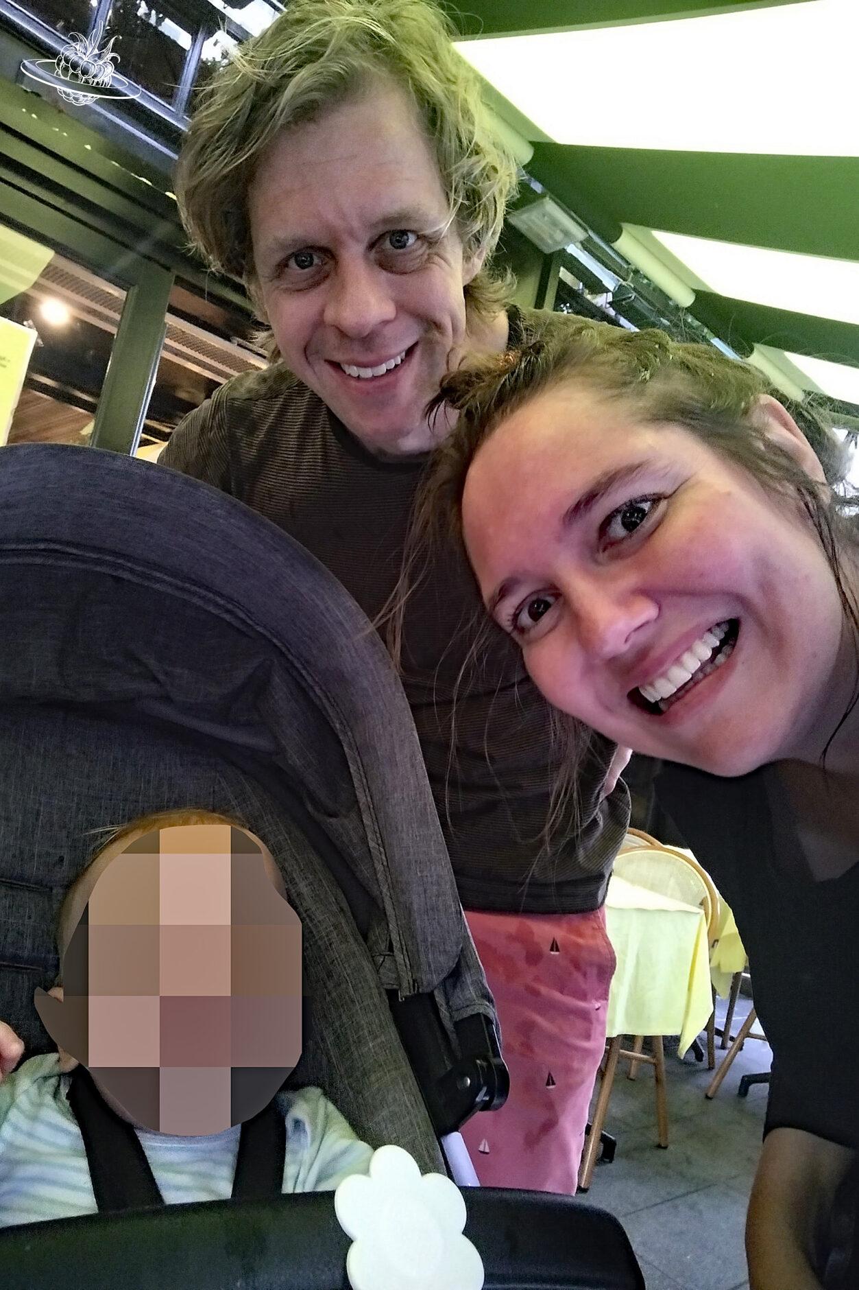 Frau und Mann mit verpixeltem Kind im Kinderwagen