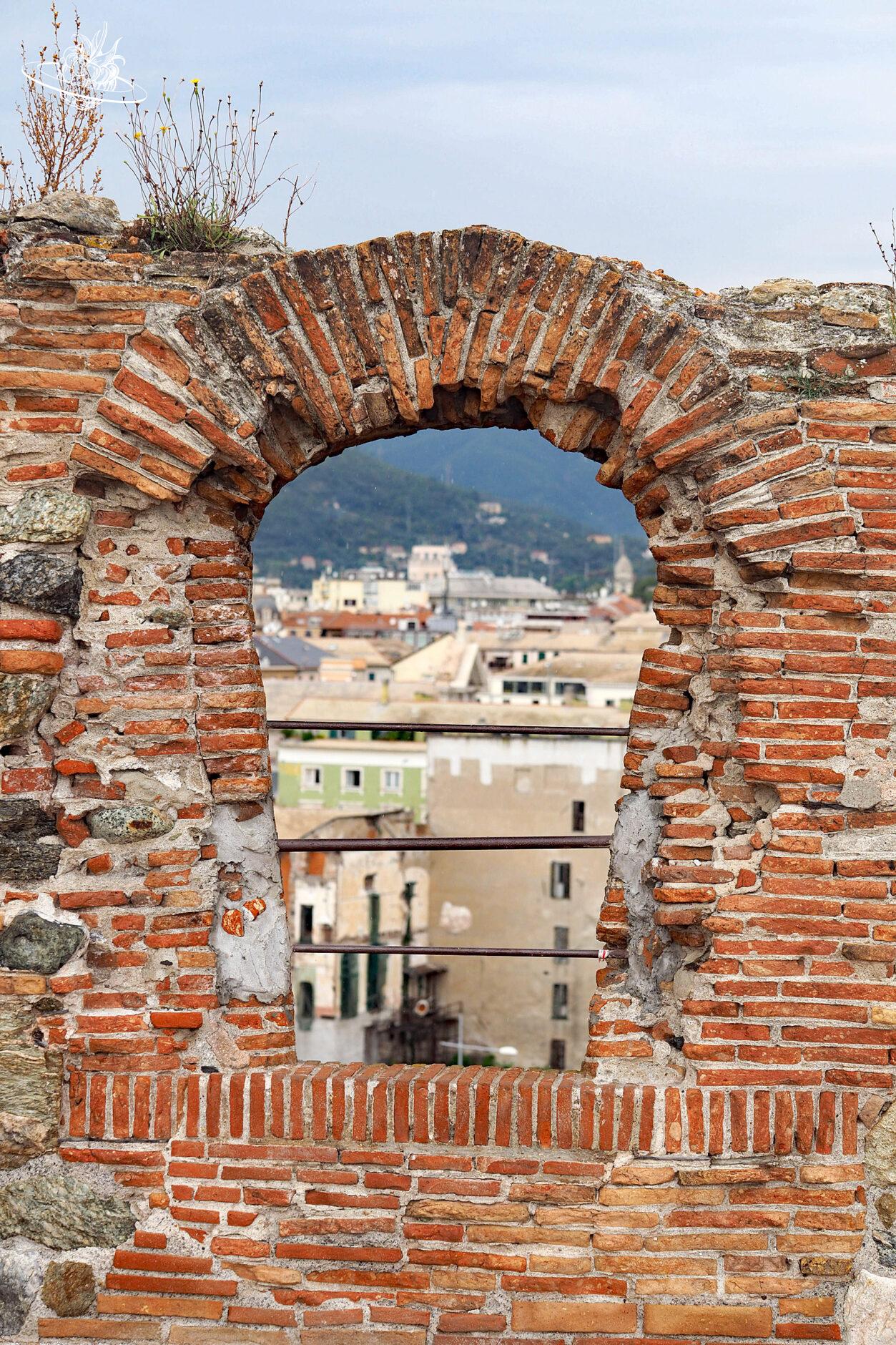 Blick durch ein altes Fenster auf die Altstadt von Savona