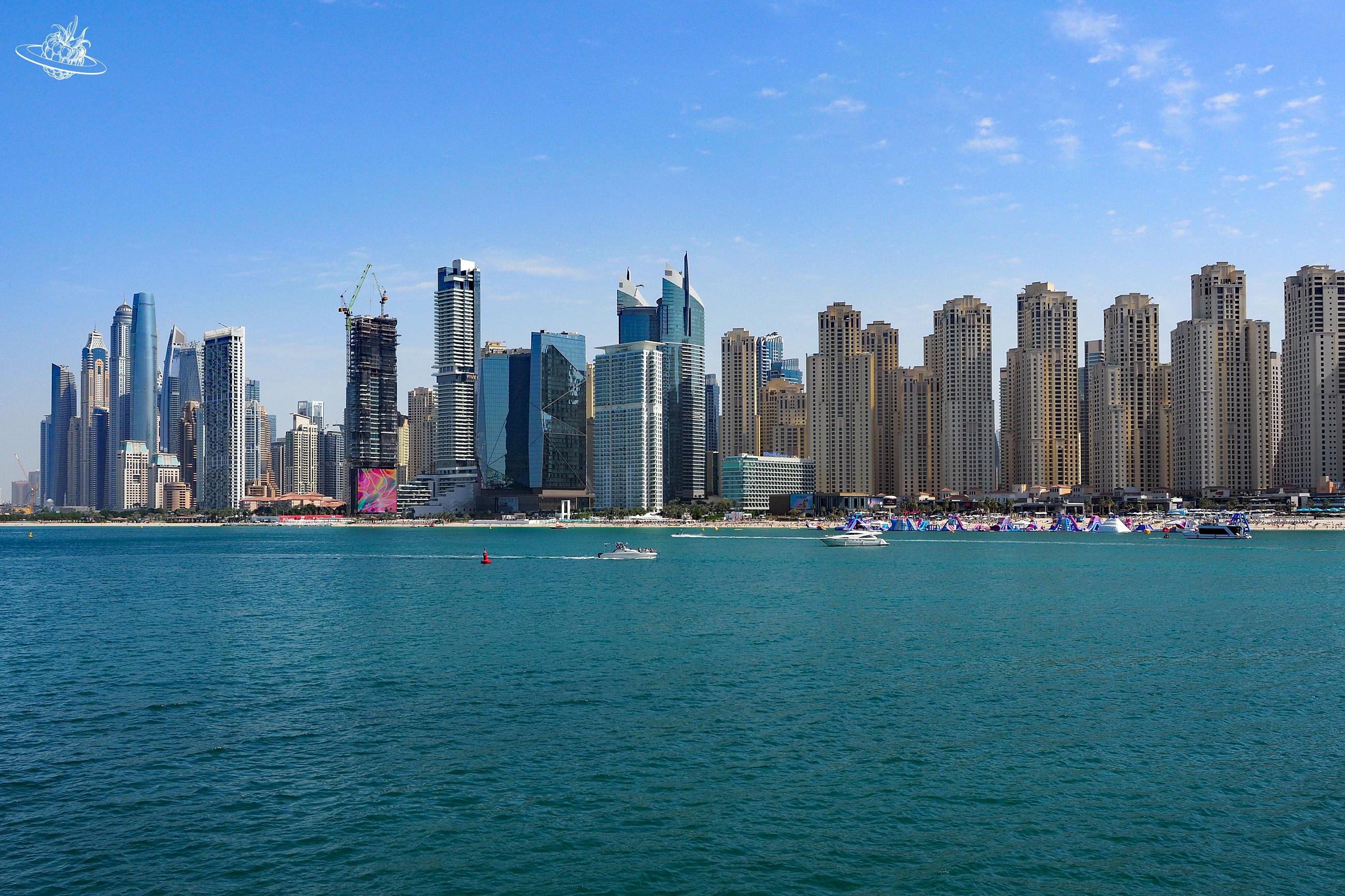 Klares Meerwasser und im Hintergrund eine Skyline von Dubai.