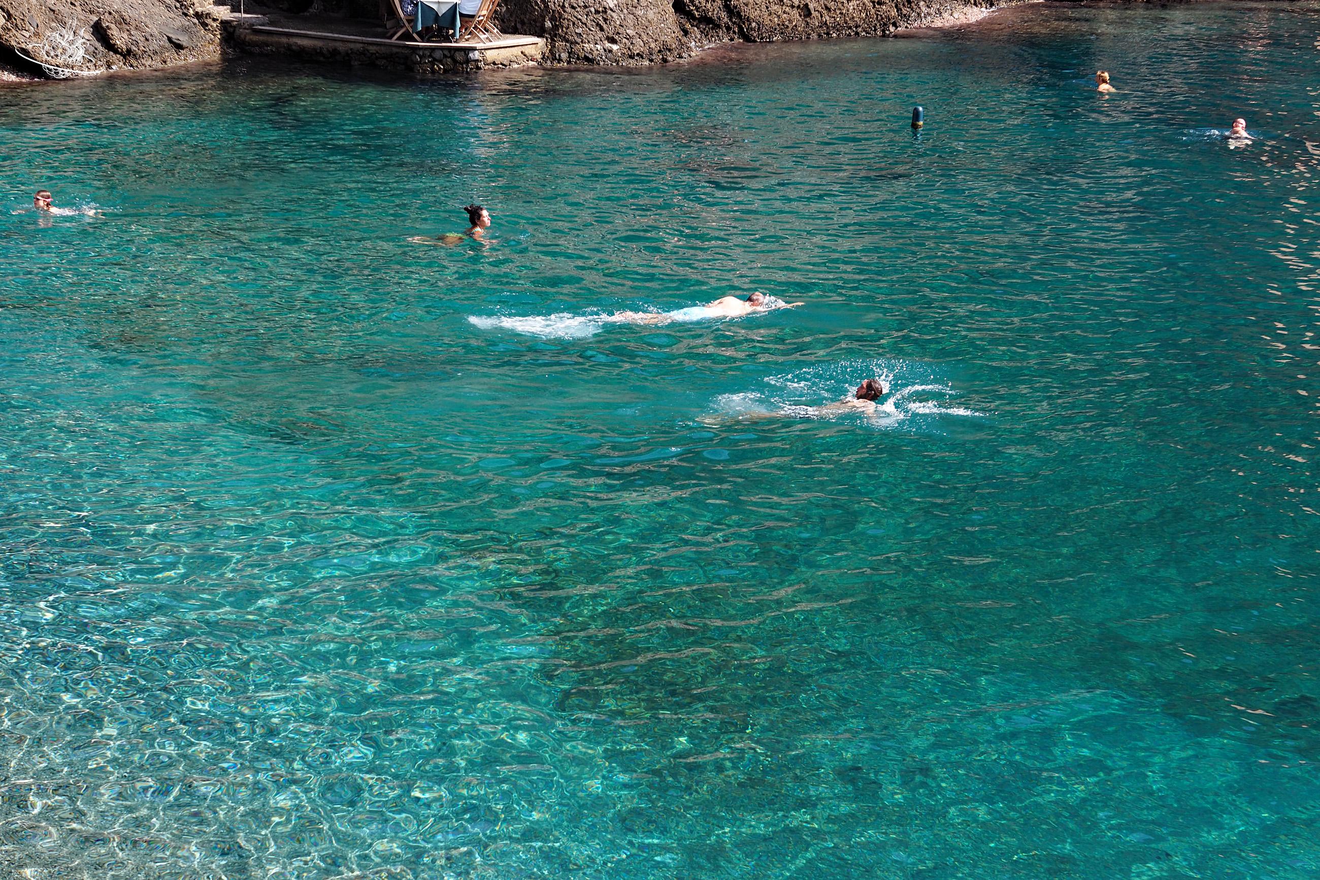 Leute baden im türkisblauen Wasser