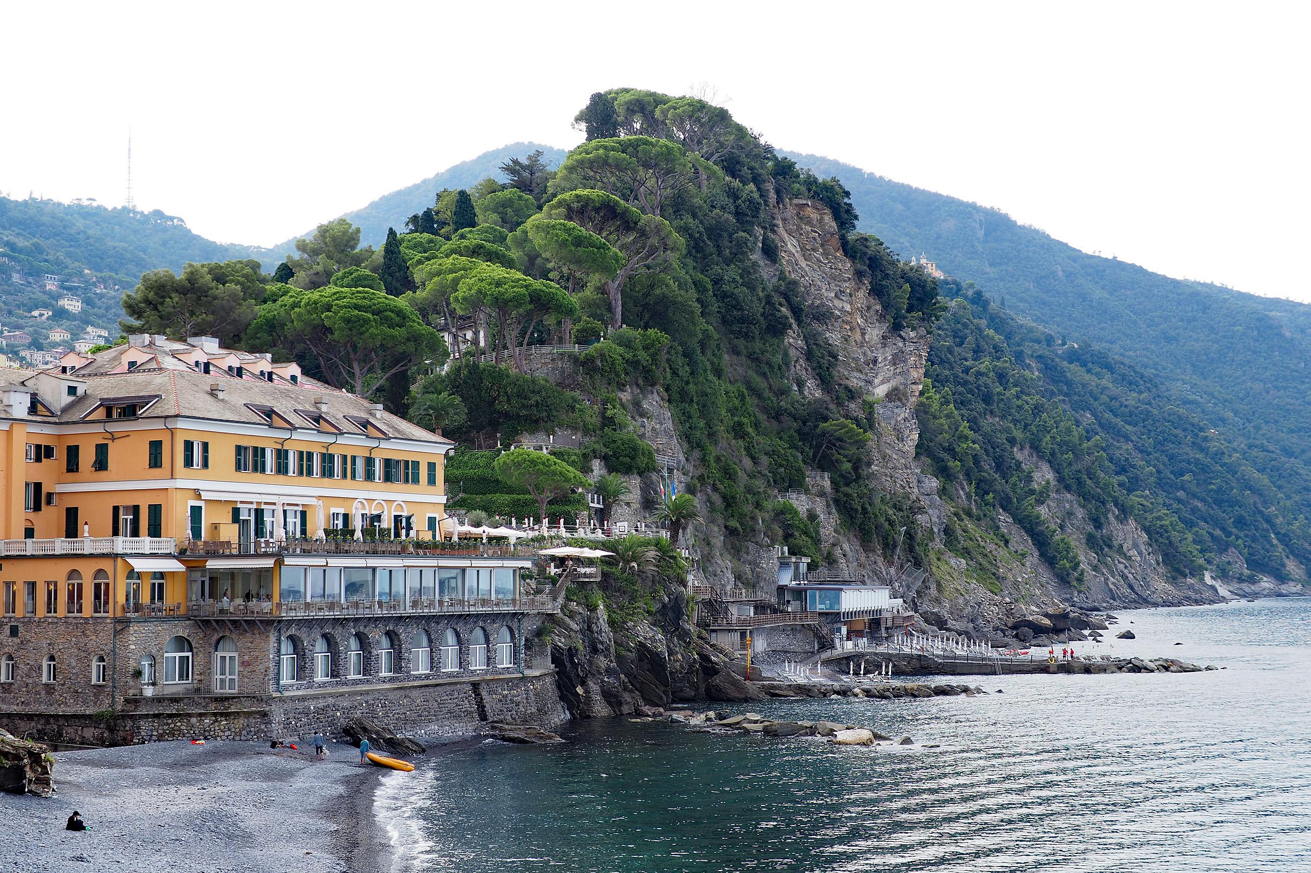 Hotel an der Küste mit steilem Fels im Hintergrund