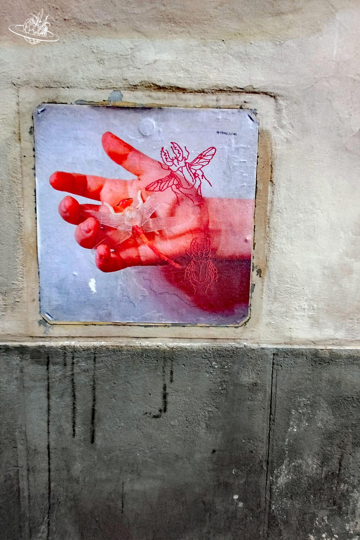 gemalenes Bild die eine Hand mit einer Blume zeigt